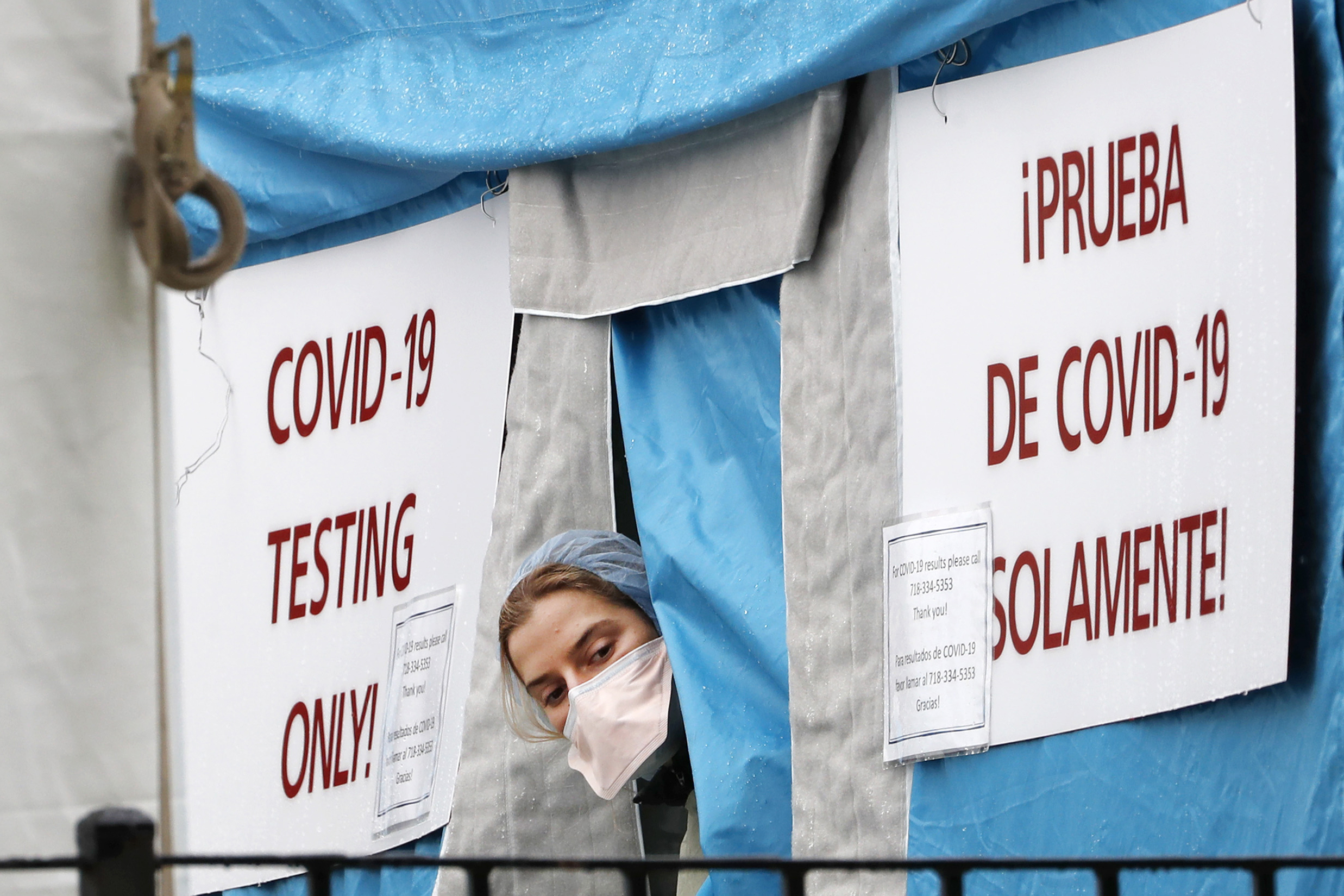 A medical worker sticks her head outside a COVID-19 testing tent set up outside Elmhurst Hospital Center in New York, Saturday, March 28, 2020. The hospital is caring for a high number of coronavirus patients in the city, and New York leads the nation in the number of cases, according to Johns Hopkins University, which is keeping a running tally.