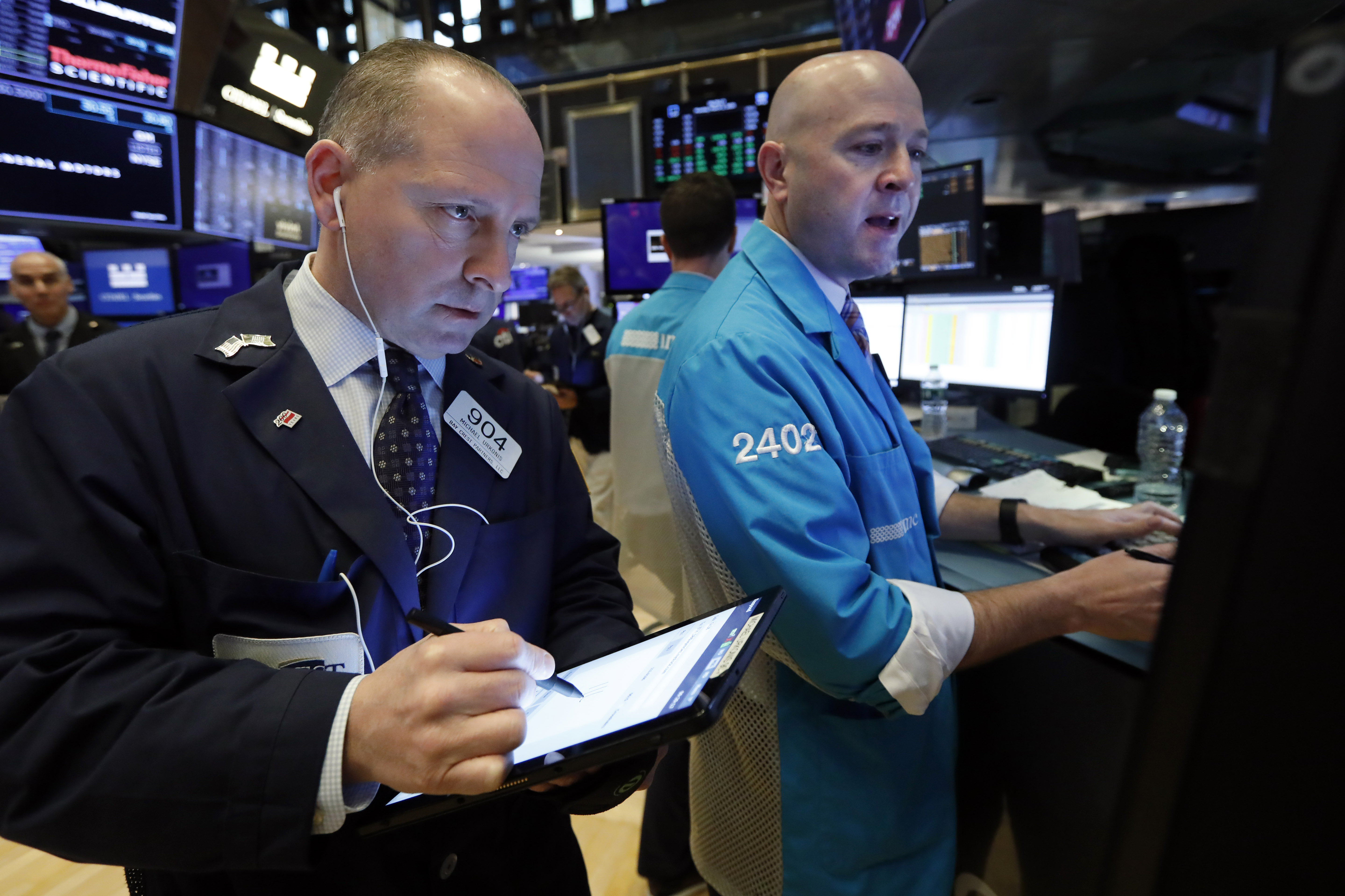 Trader Michael Urkonis, left, and specialist Jay Woods work on the floor of the New York Stock Exchange, Monday, March 2, 2020.