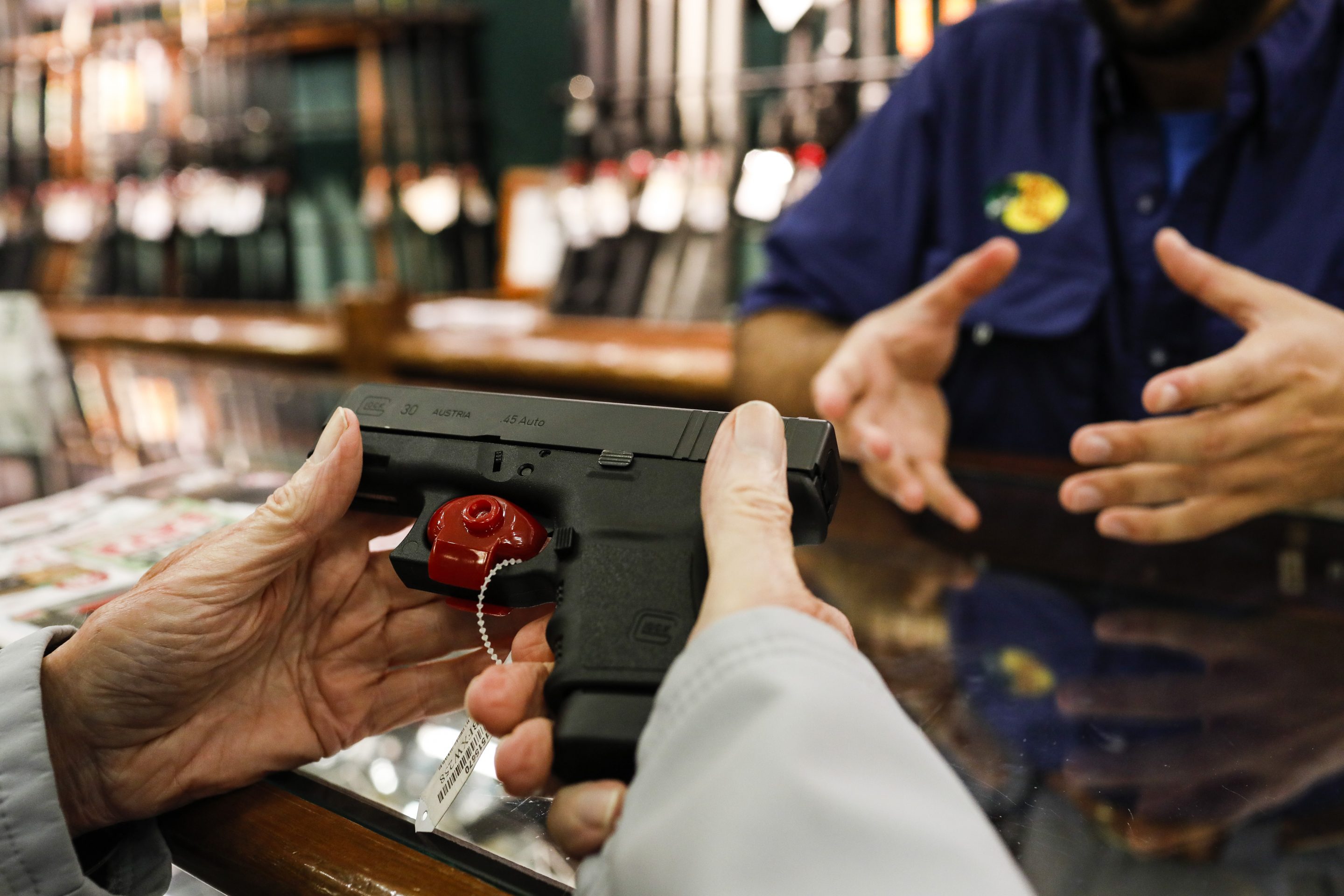 A shopper browses a handheld firearm for sale inside a Bass Pro Outdoor World LLC store on Black Friday in Tampa, Florida, U.S., on Friday, Nov. 23, 2018. Deloitte expects sales from November to January to rise as much as 5.6 percent, to more than $1.1 trillion, marking the best holiday period in recent memory.