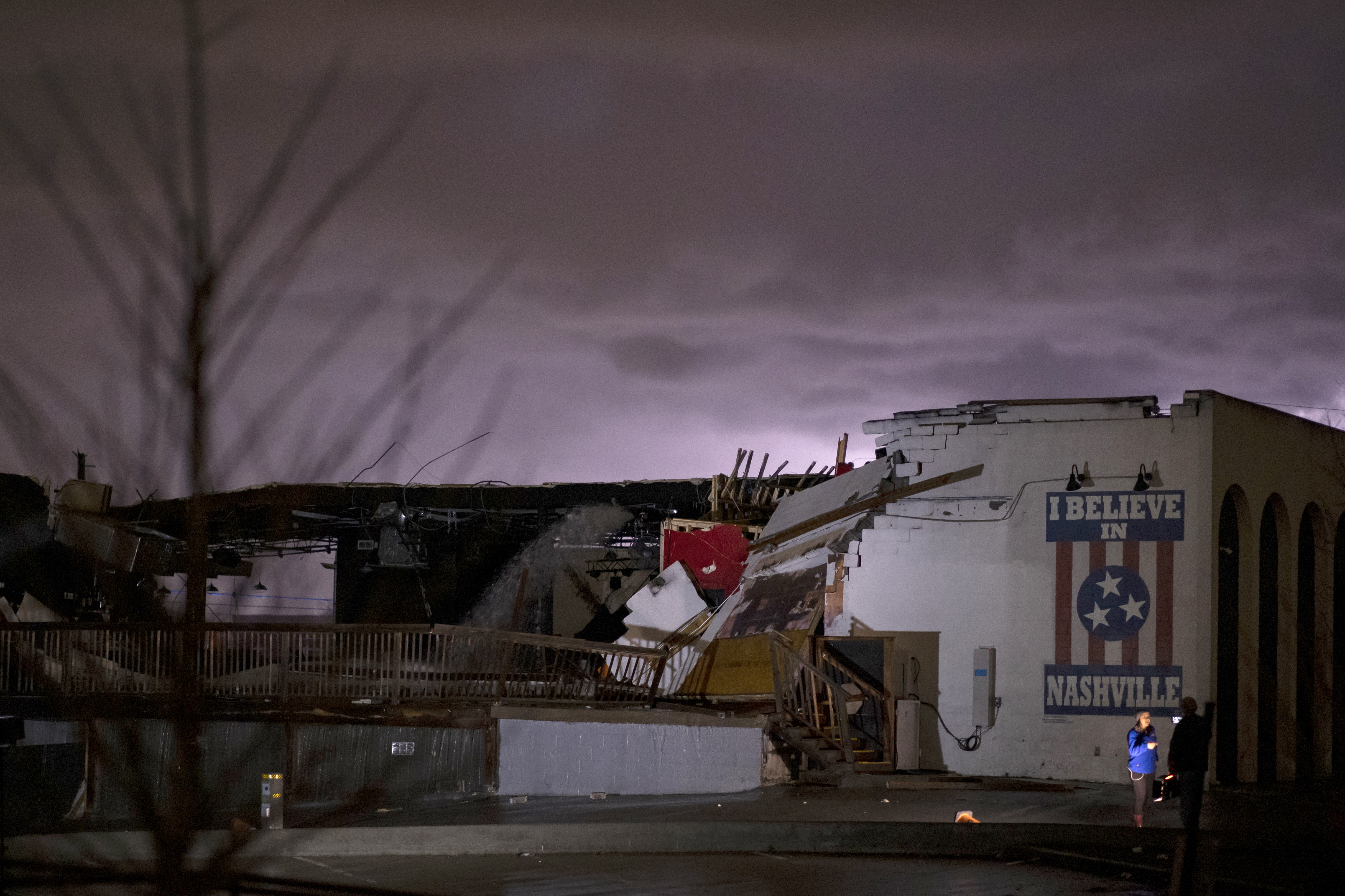 NASHVILLE, TN - MARCH 03: A television news crew works in front of a mural on heavily damaged The Basement East in the East Nashville neighborhood as lightning strikes in the background on March 3, 2020 in Nashville, Tennessee. A tornado passed through Nashville just after midnight leaving a wake of damage in its path including two people killed in East Nashville. (Photo by Brett Carlsen/Getty Images)