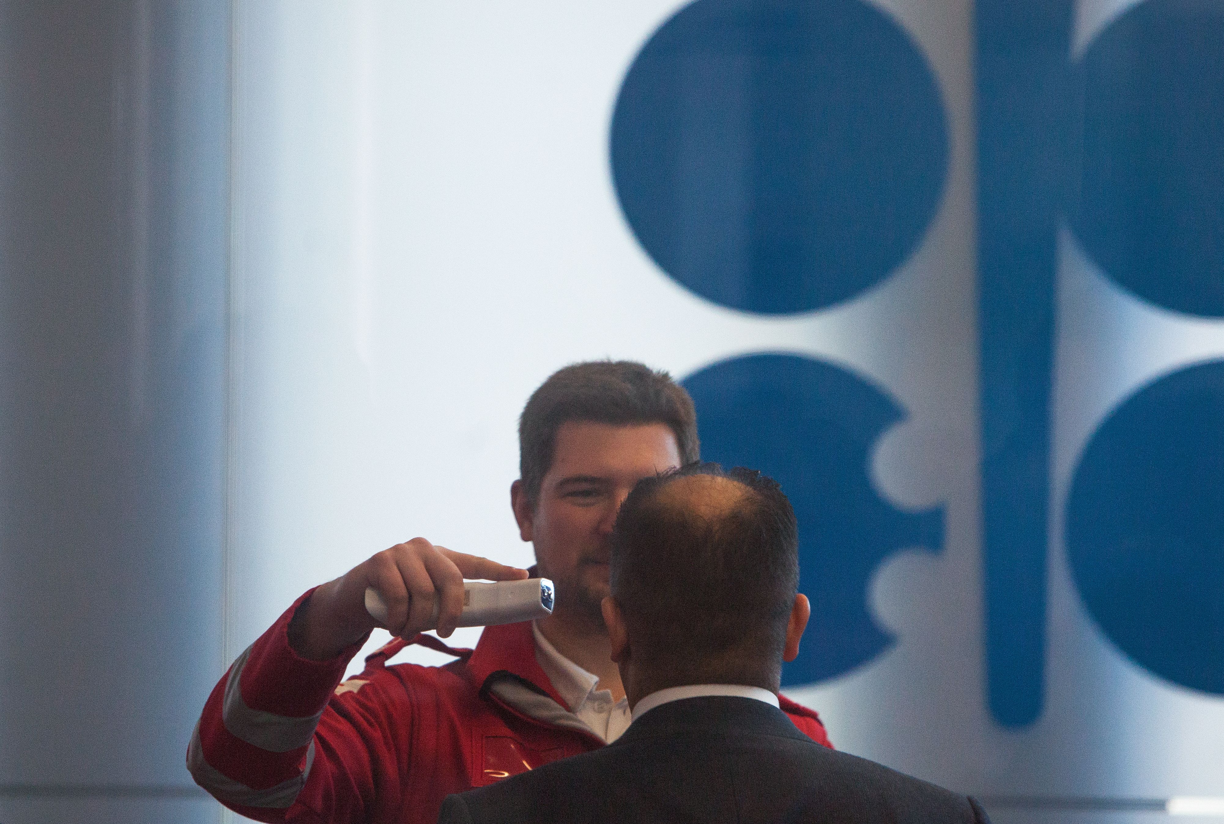 A Red Cross medic measures the temperature of a participant of the 178th Organization of Petroleum Exporting Countries (OPEC) meeting in Vienna, Austria, on March 5, 2020. Talks broke down on supply limits, sending the oil prices reeling on Monday. Wire photography: Alex Halada—AFP via Getty Images.