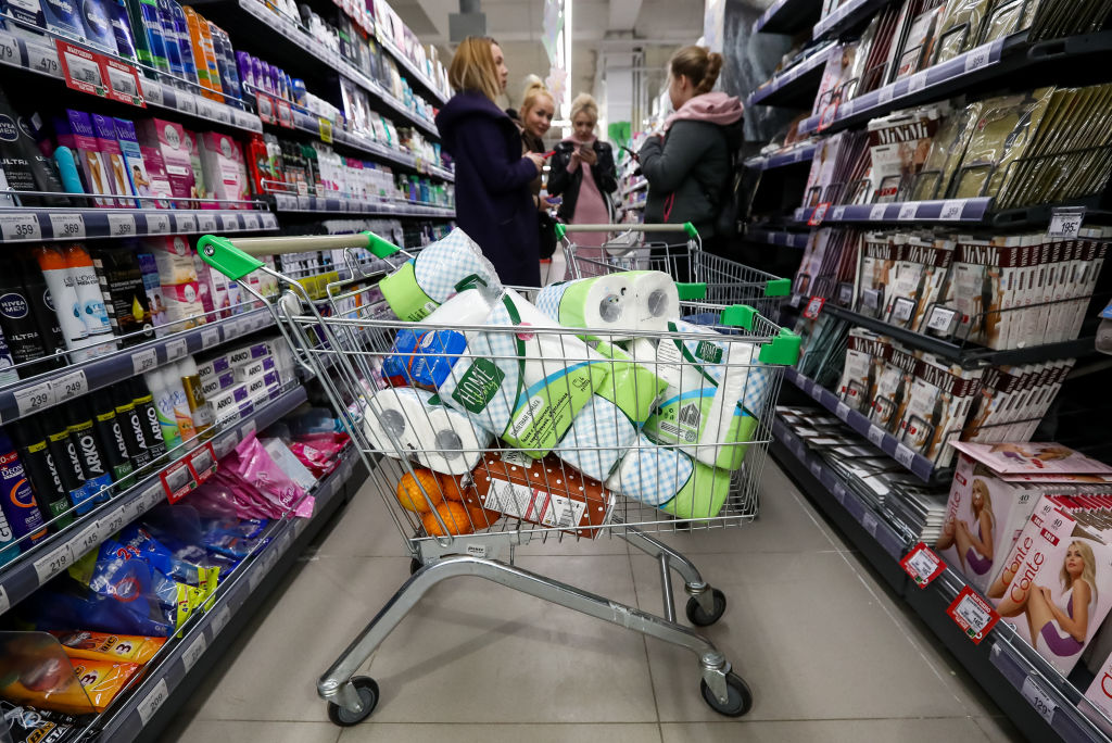 A shopping cart full of toilet paper rolls.