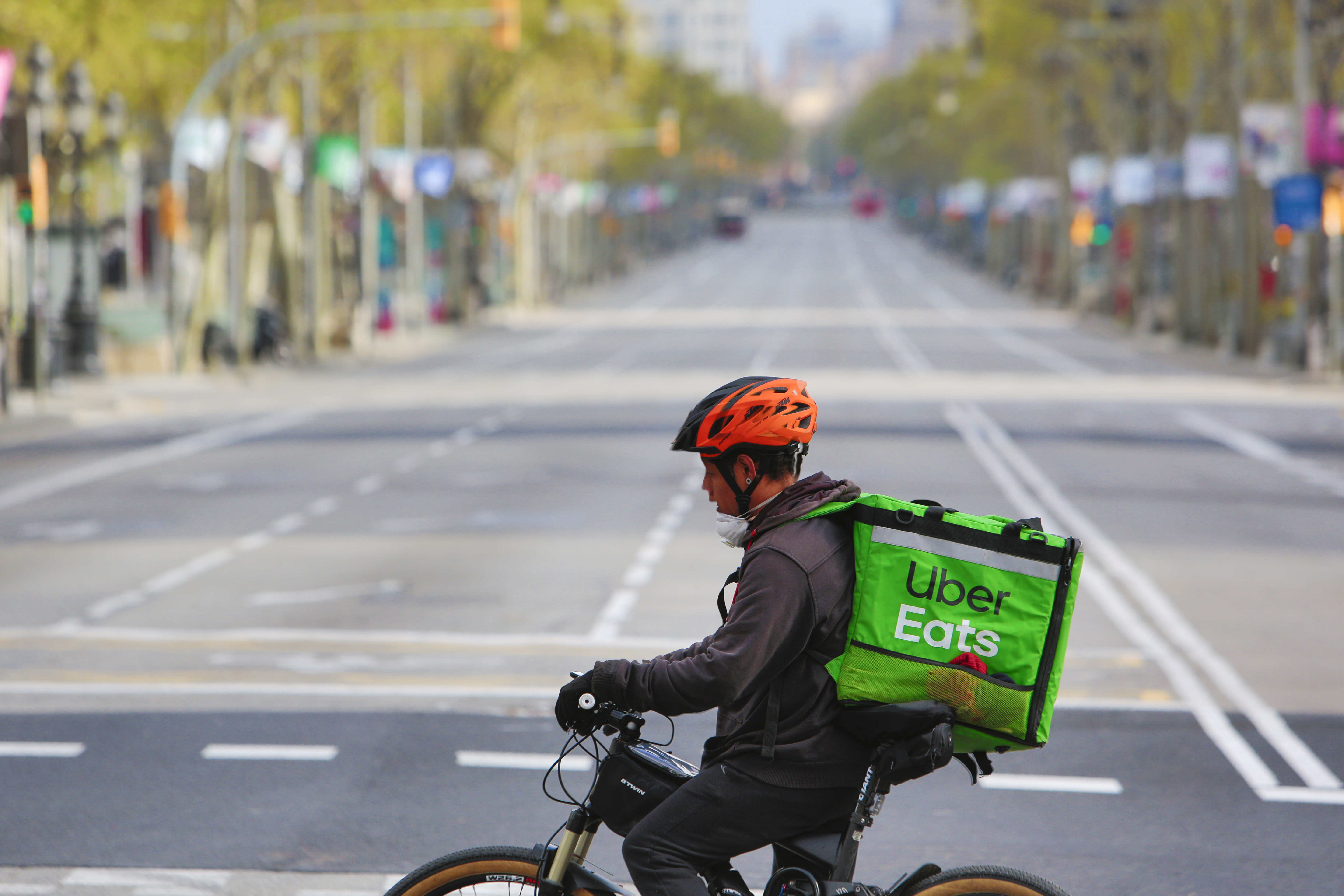 BARCELONA, SPAIN - MARCH 22: A cyclist Uber delivery rides his bike at Passeig de Gracia boulevard empty of visitors, tourists and no traffic on March 22, 2020 in Barcelona, Spain. The coronavirus (COVID-19) pandemic has spread to at least 182 countries, claiming over 10,000 lives and infecting hundreds of thousands more. (Photo by Miquel Benitez/Getty Images)