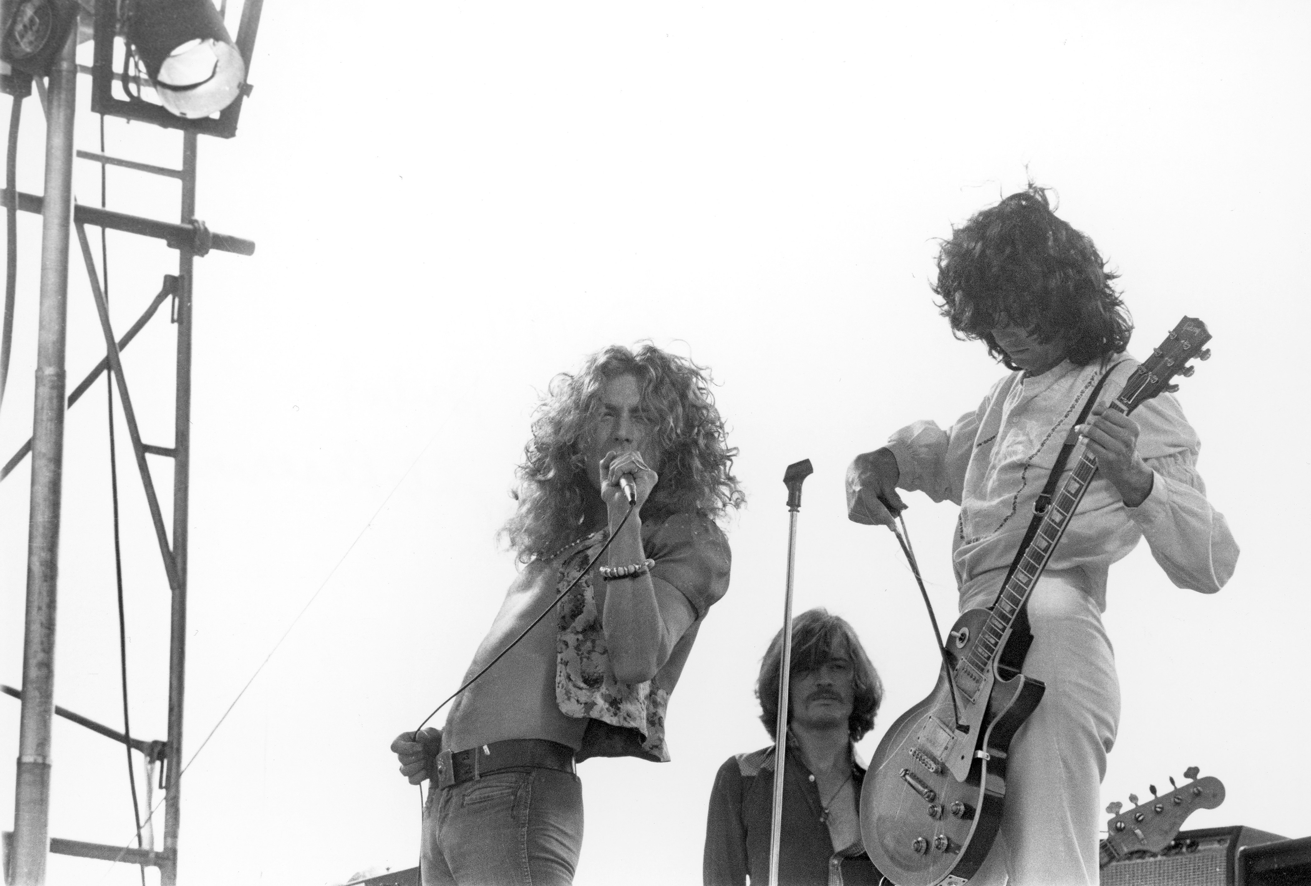 SAN FRANCISCO - JUNE 2: Singer Robert Plant, bassist John Paul Jones and guitarist Jimmy Page of the rock band 'Led Zeppelin' perform at Kezar Stadium on June 2, 1973 in San Francisco, California. Jimmy Page plays his Gibson Les Paul electric guitar with a bow. (Photo by Larry Hulst/Michael Ochs Archives/Getty Images)