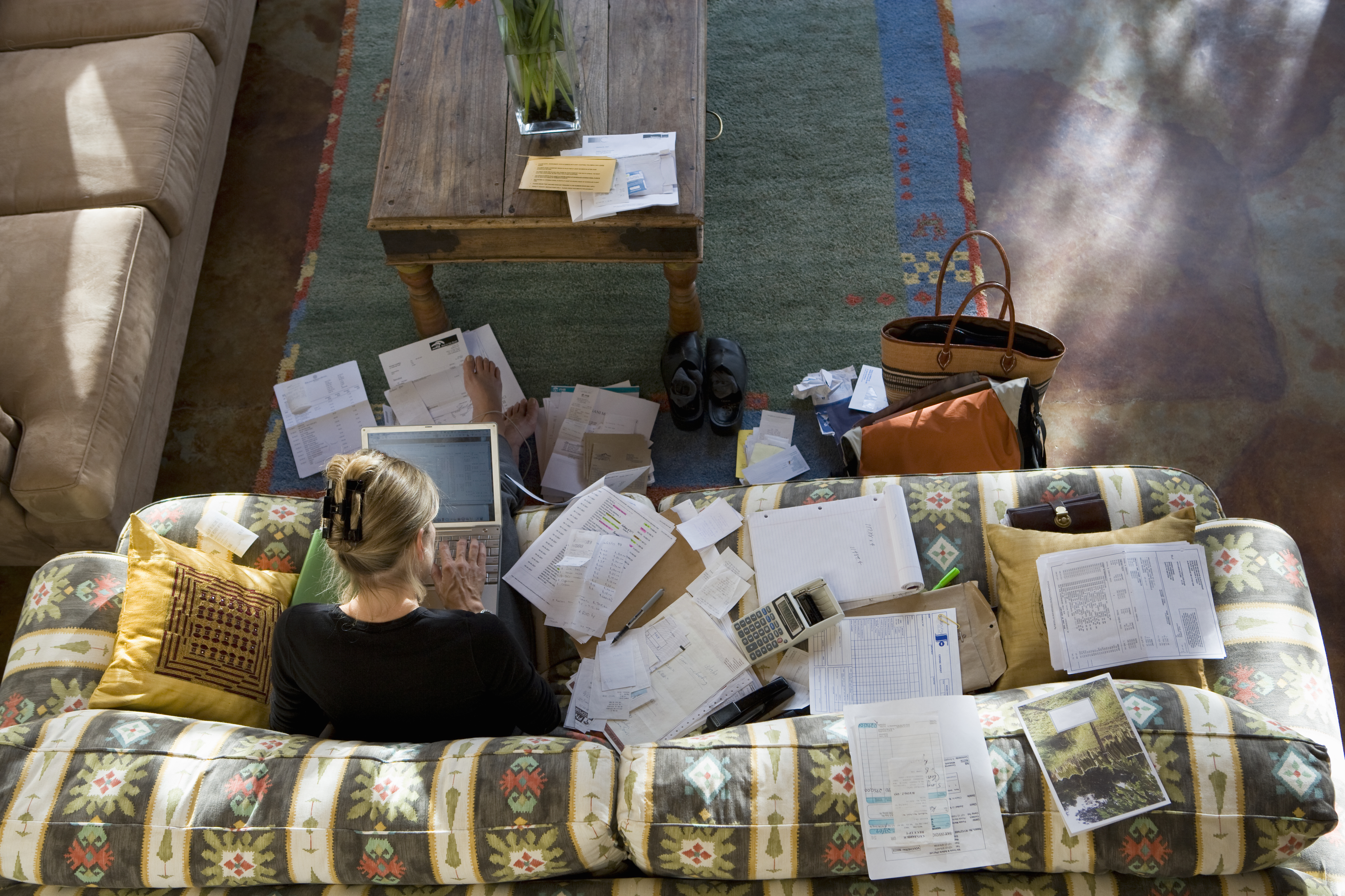 A woman works from her couch at home.