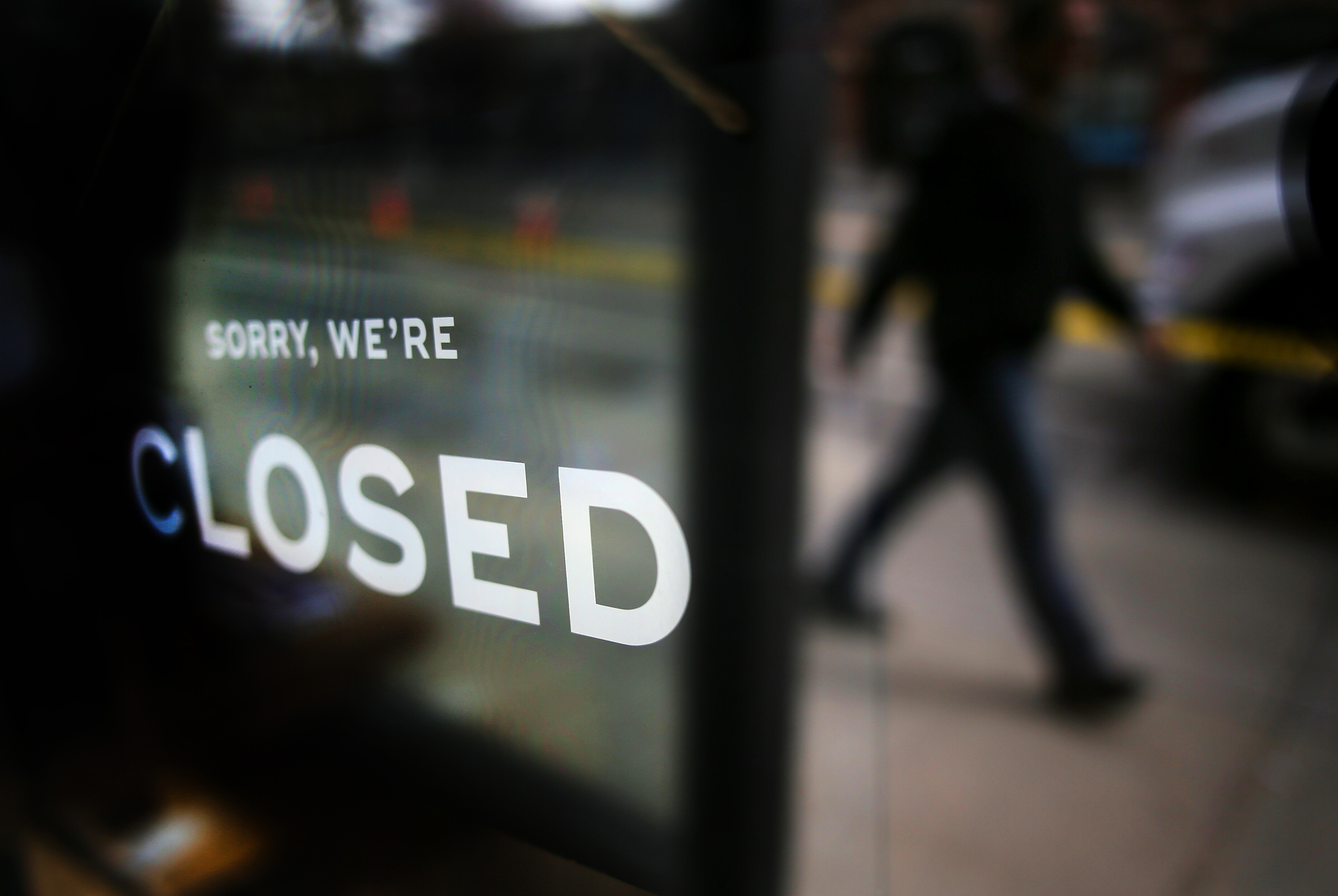 BROOKLINE, MA - MARCH 24: A business posts a sign alerting its customers that it is closed in Coolidge Corner in Brookline, MA during the COVID-19 pandemic. The city empties out a day after Governor Charlie Baker issued a stay at home advisory for all non-essential workers as a way to reduce the spread of coronavirus and flatten the COVID-19 curve.  (Photo by Lane Turner/The Boston Globe via Getty Images)
