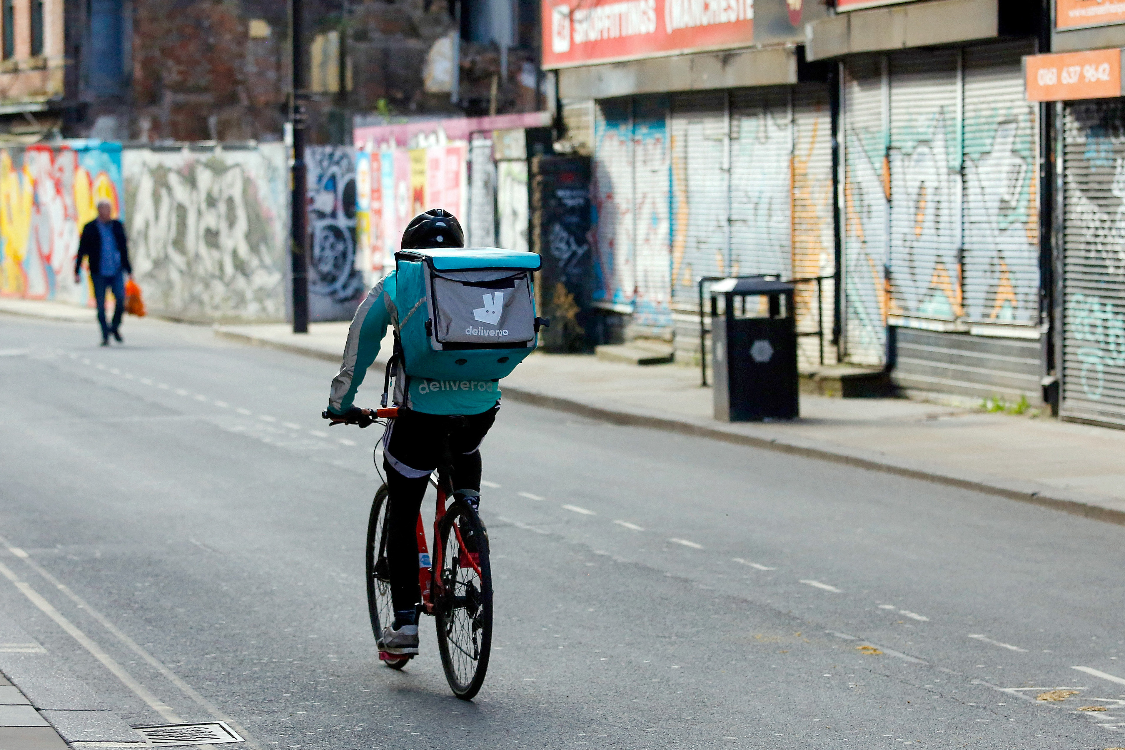 A food delivery courier for Deliveroo cycles in Manchester, U.K. The food delivery startup has been a lifeline to locked-down Britons since the coronavirus crisis shut restaurants. But the outbreak is hurting business. Wire photography: Paul Thomas—Bloomberg via Getty Images