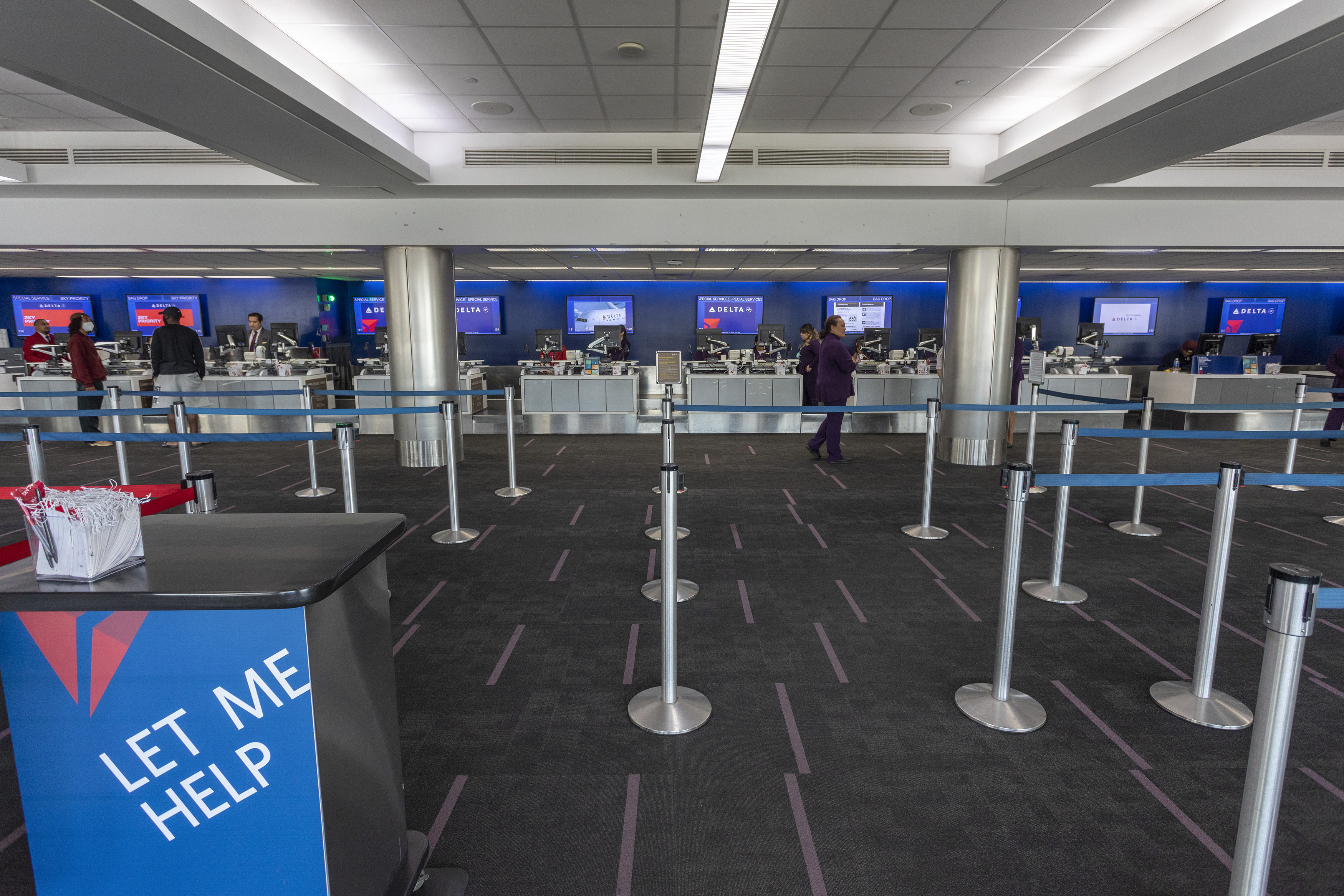 Employees at the Delta Air Lines counters wait for customers at a nearly deserted Los Angeles International Airport due to the coronavirus pandemic on April 16, 2020 in Los Angeles, California. Passenger air travel has plummeted more than 90 percent at LAX as airlines slash flights and consolidate operations since COVID-19 has forced most travelers to stay home.