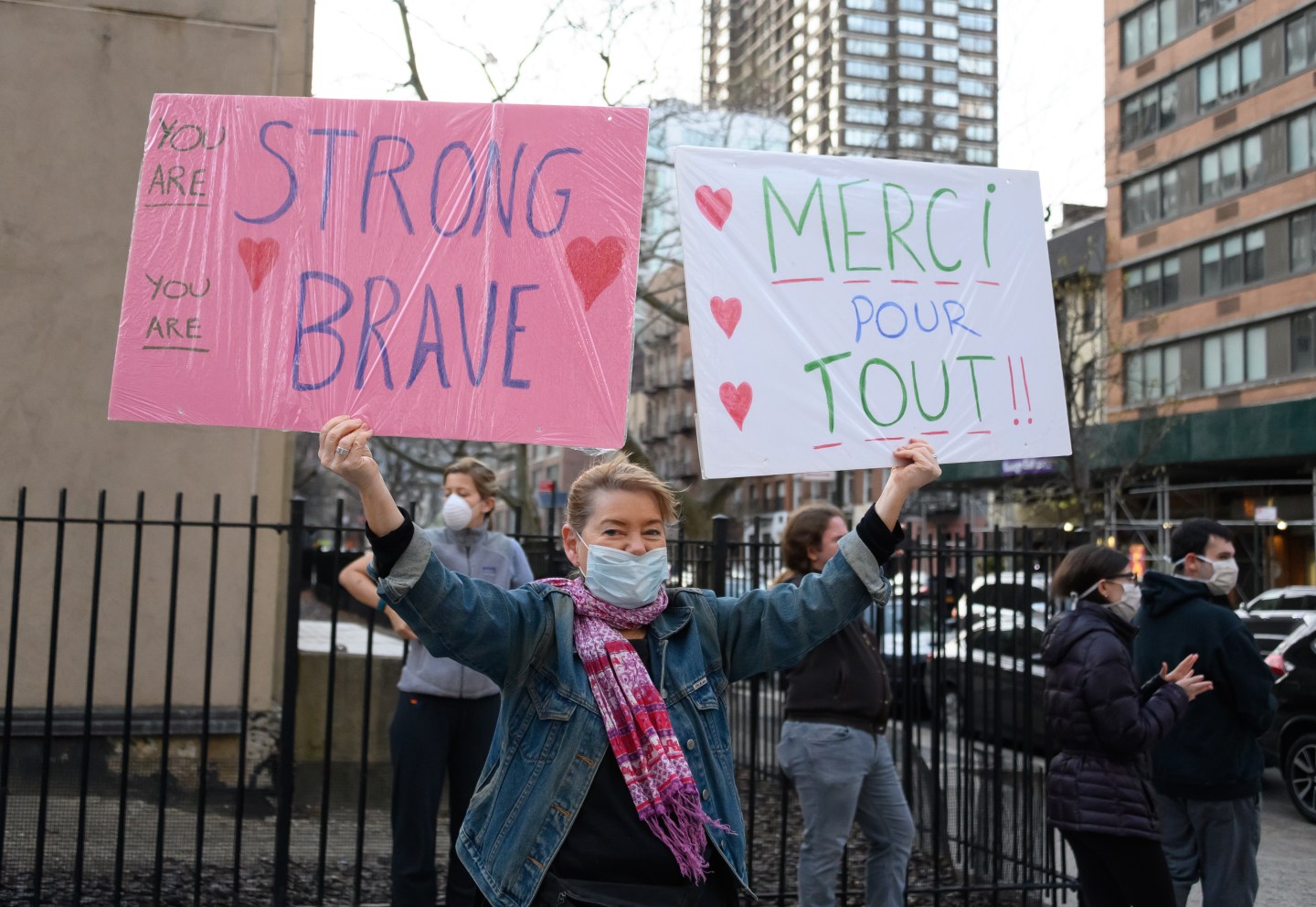 NEW YORK, NY - APRIL 06: A person holds up two signs, one in english and one in french reading, "You Are Strong, You Are Brave" and "Merci Pour Tout!!" near NYU Langone Health hospital to show their gratitude to medical staff and essential workers during the coronavirus pandemic on April 6, 2020 in New York City.