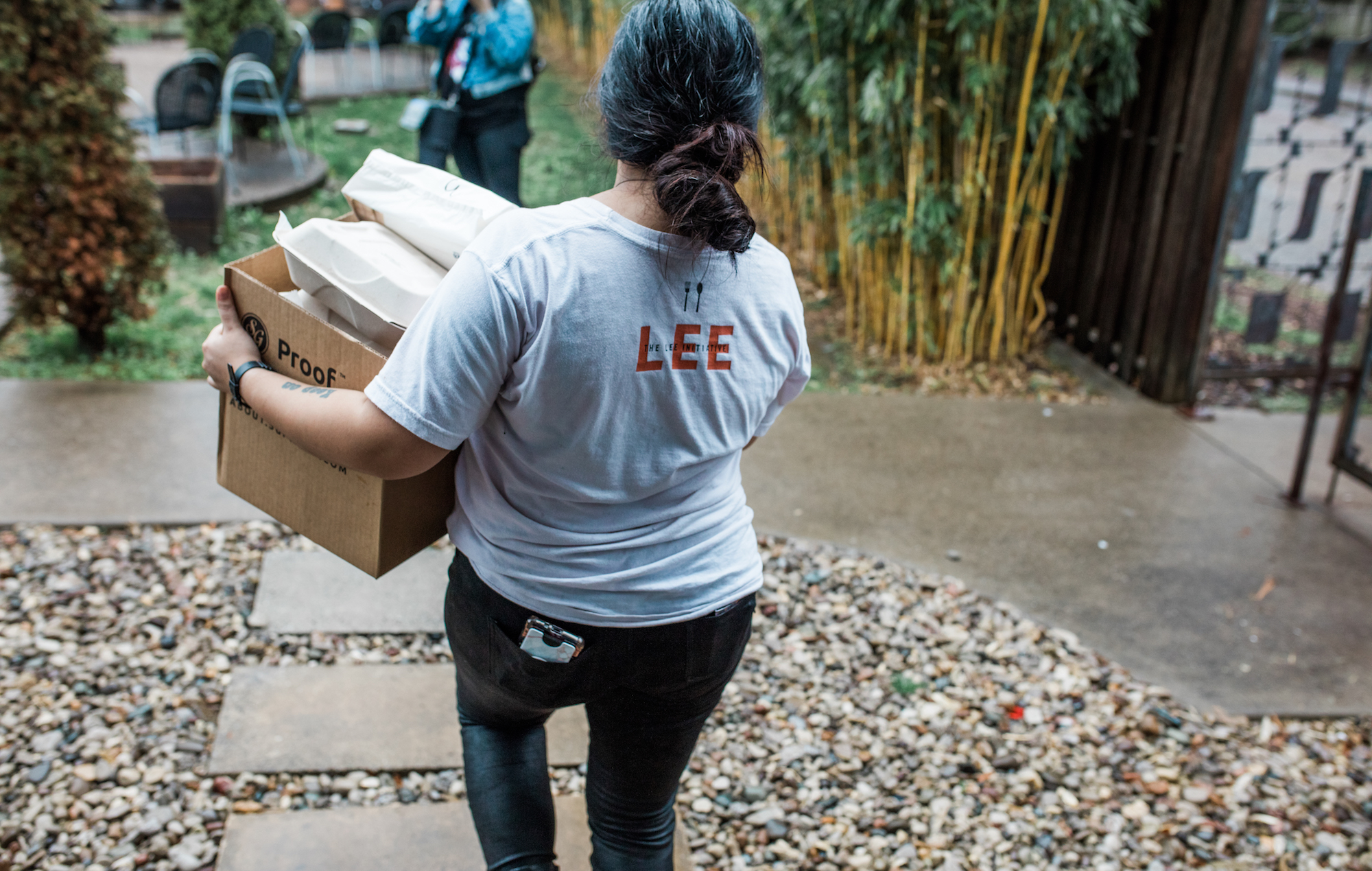 A volunteer for the LEE Initiative carries care packages for restaurant workers in Louisville, Ky.