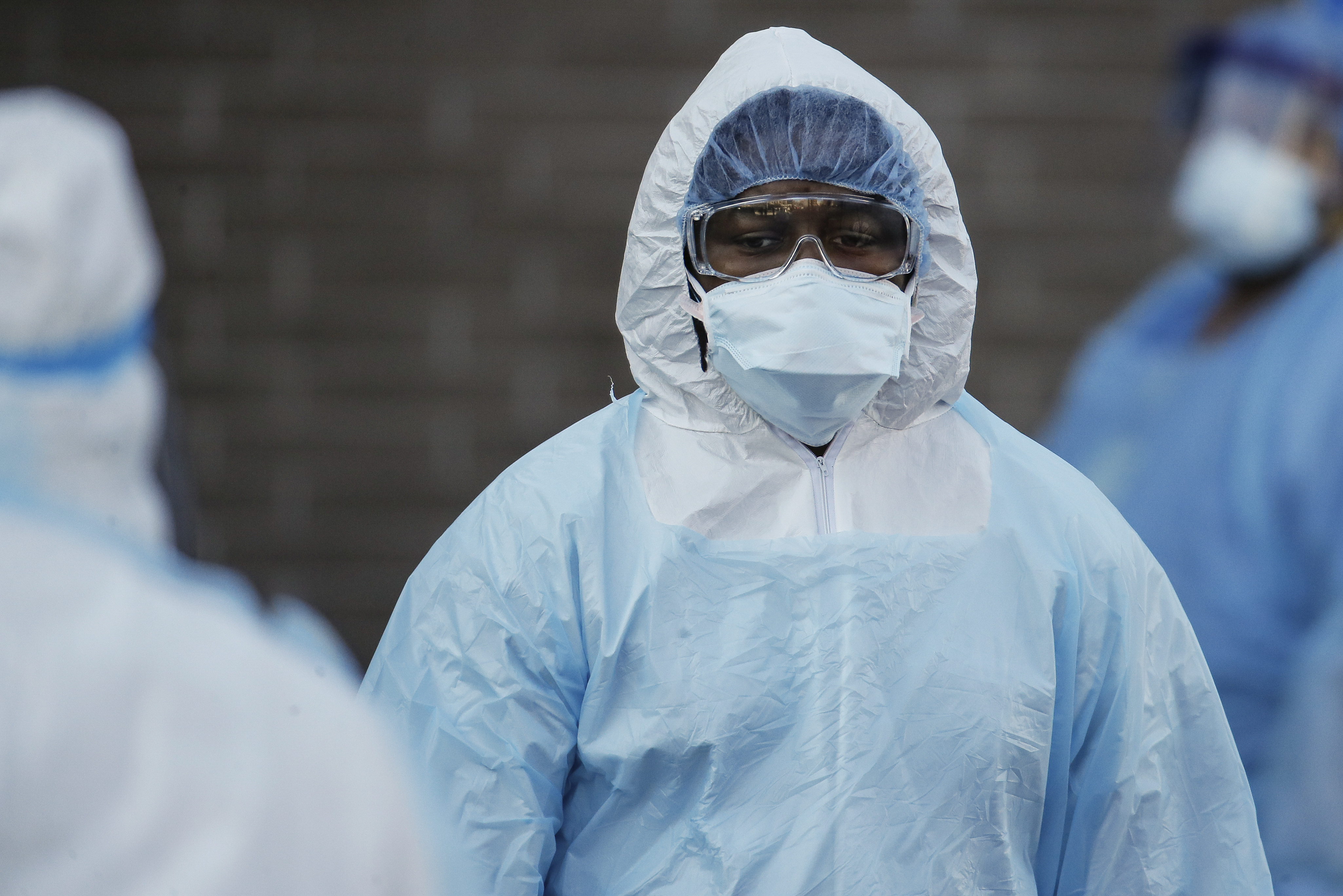 A medical worker wearing personal protective equipment pauses after wheeling a body to a refrigerated trailer serving as a makeshift morgue at Wyckoff Heights Medical Center in the Brooklyn borough of New York. John Minchillo—AP Images