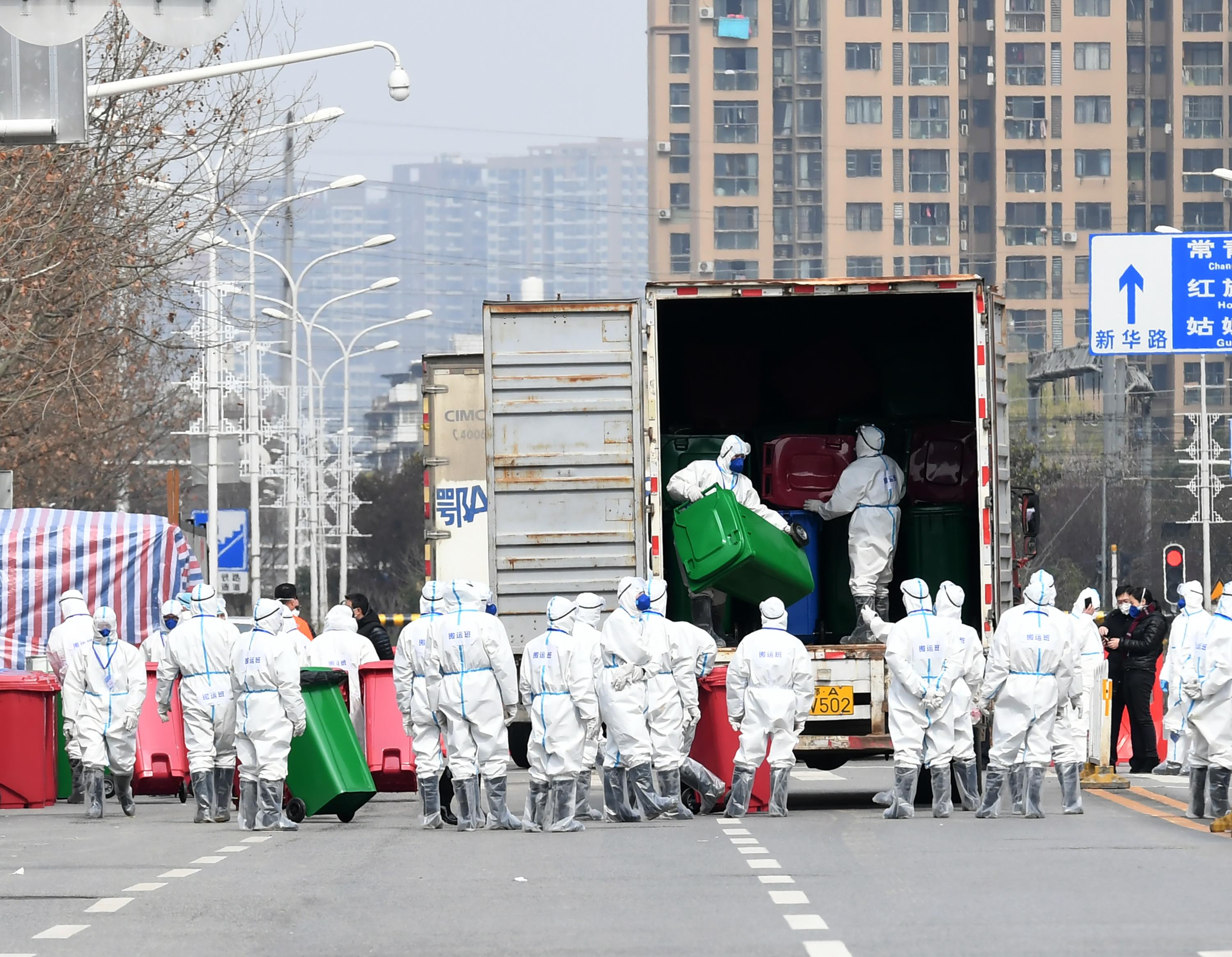 People in March wearing protective masks and suits carry rubbish bins during disinfection work at Huanan Wholesale Seafood Market in Wuhan, Hubei Province of China. WHO scientists on Friday said they are considering a new mission to China to get more information about the virus’s animal origin. Wire photography: An Yuan—China News Service via Getty Images