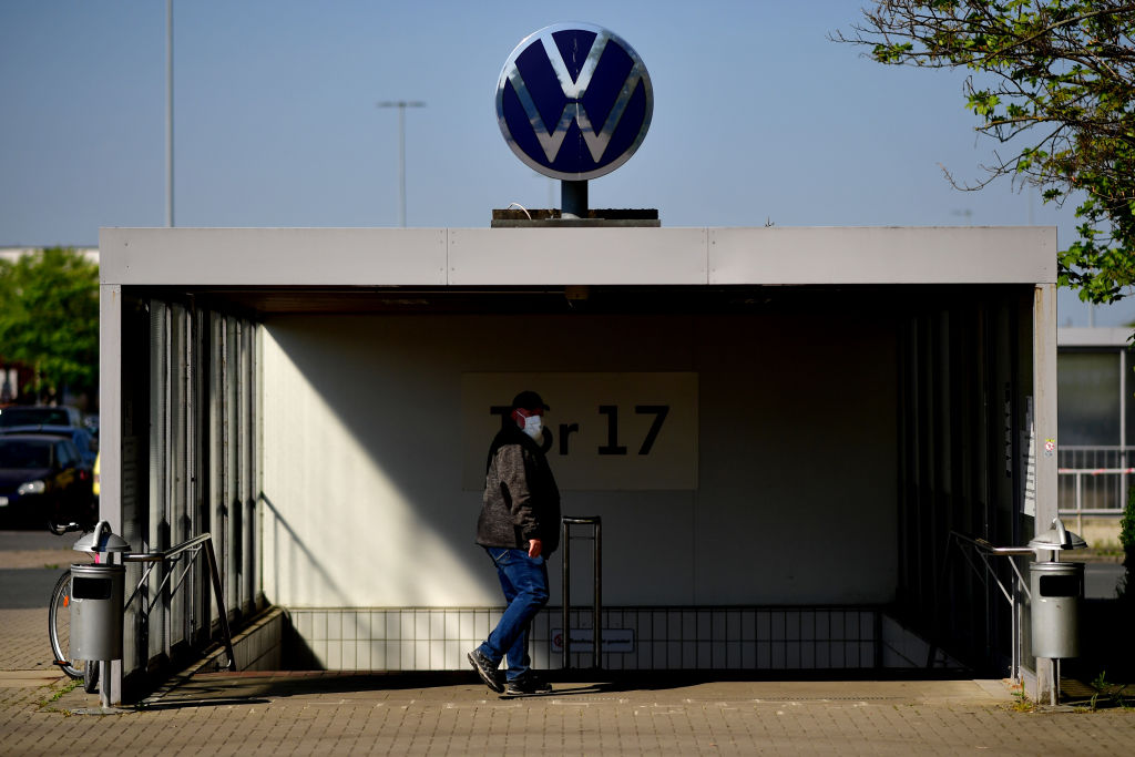 WOLFSBURG, GERMANY - APRIL 27: An Volkswagen employee wears a mask walks by the Volkswagen factory during the coronavirus crisis on April 27, 2020 in Wolfsburg, Germany. Production was shut down in March due to both to lockdown measures designed to stem the spread of the virus and the breakdown of international supply chains. Germany is taking steps to lift lockdown measures in a careful attempt to get the economy back into gear.