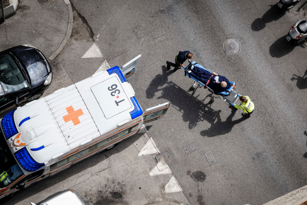 A man on a stretcher is carried towards an ambulance during the coronavirus pandemic, in Trieste, Italy, on May 1, 2020. Extensive blood clots have now been linked to COVID-19