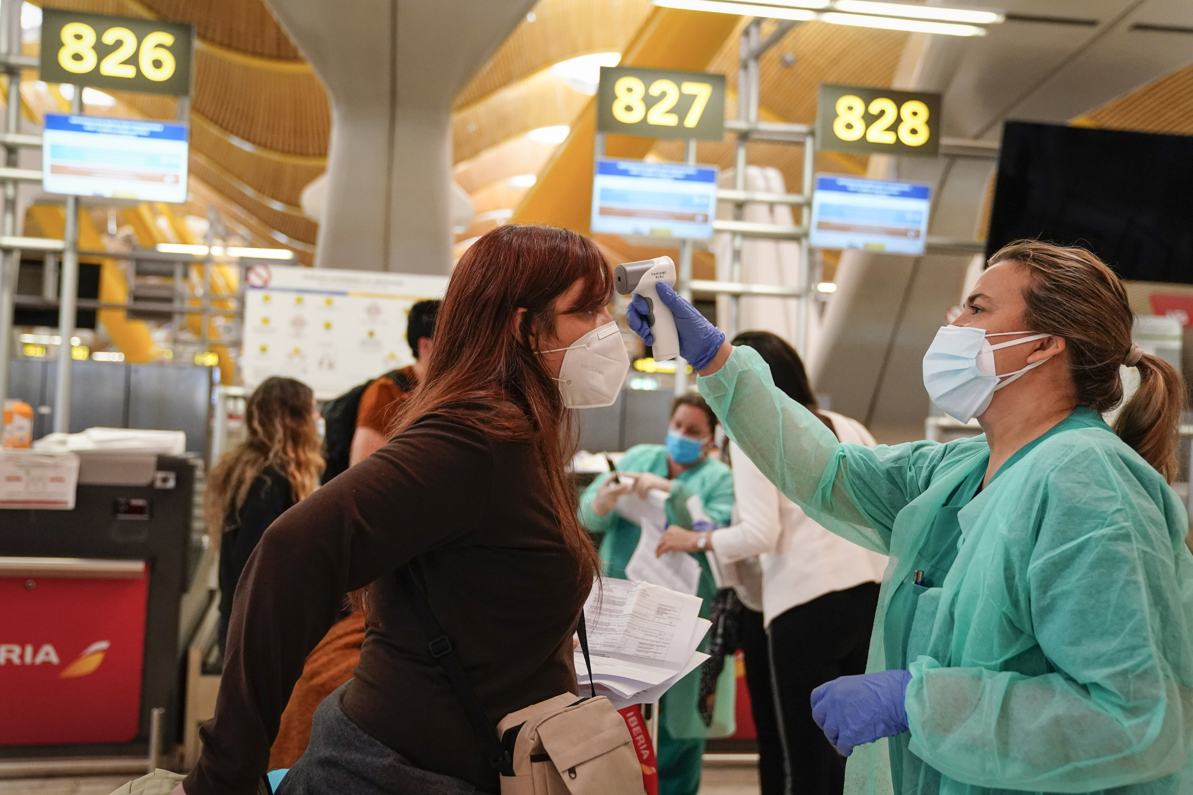 A medical worker checks the temperatures of a passenger at the check-in counters inside the departures terminal at Madrid Barajas airport this month. Air traffic volumes are not expected to return to pre-pandemic levels for another three years. Wire photography: Paul Hanna—Bloomberg via Getty Images