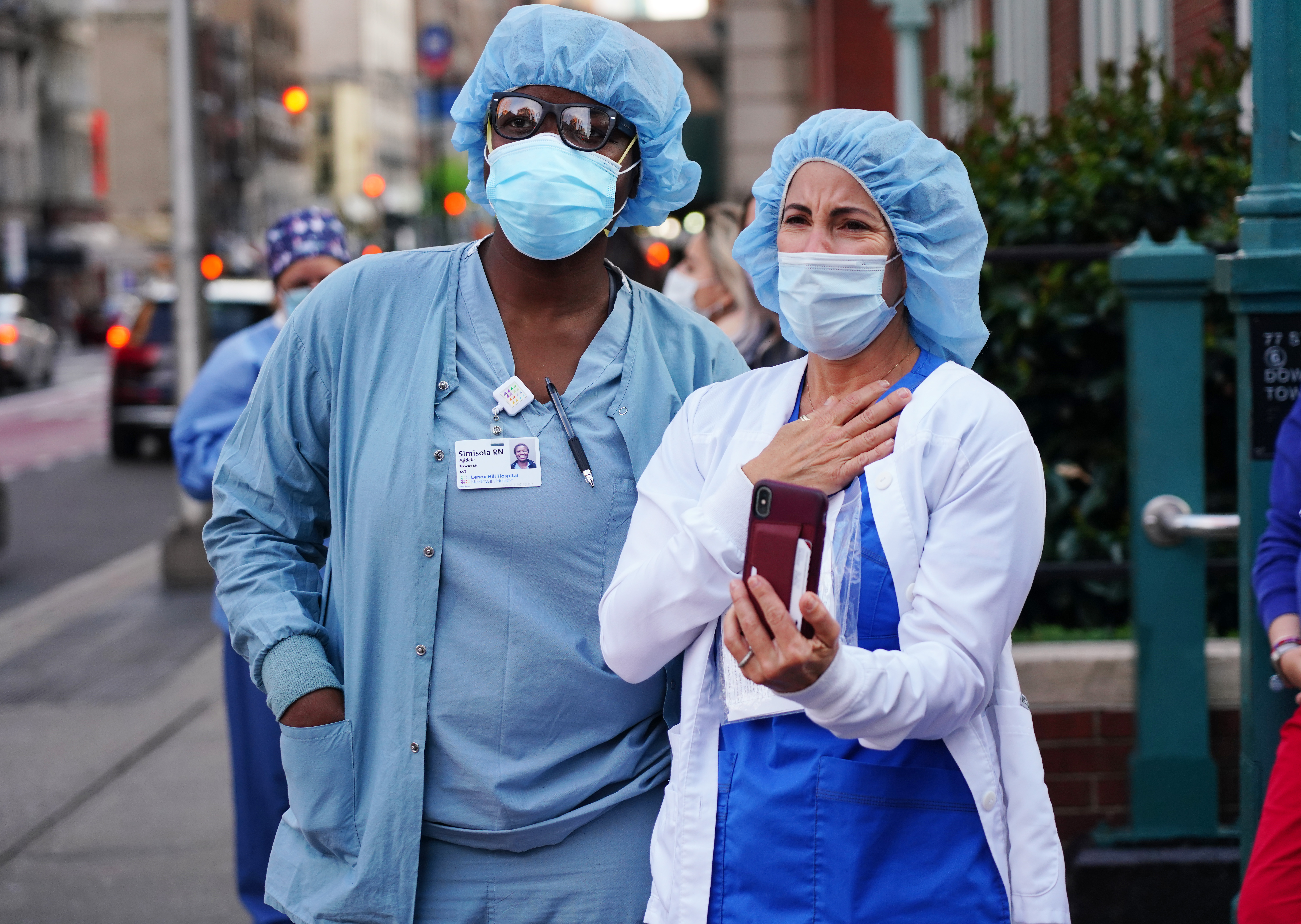 Medical workers from Lenox Hill Hospital come outside while people show gratitude as part of the nightly #ClapBecauseWeCare during the coronavirus pandemic on May 10, 2020 in New York City.