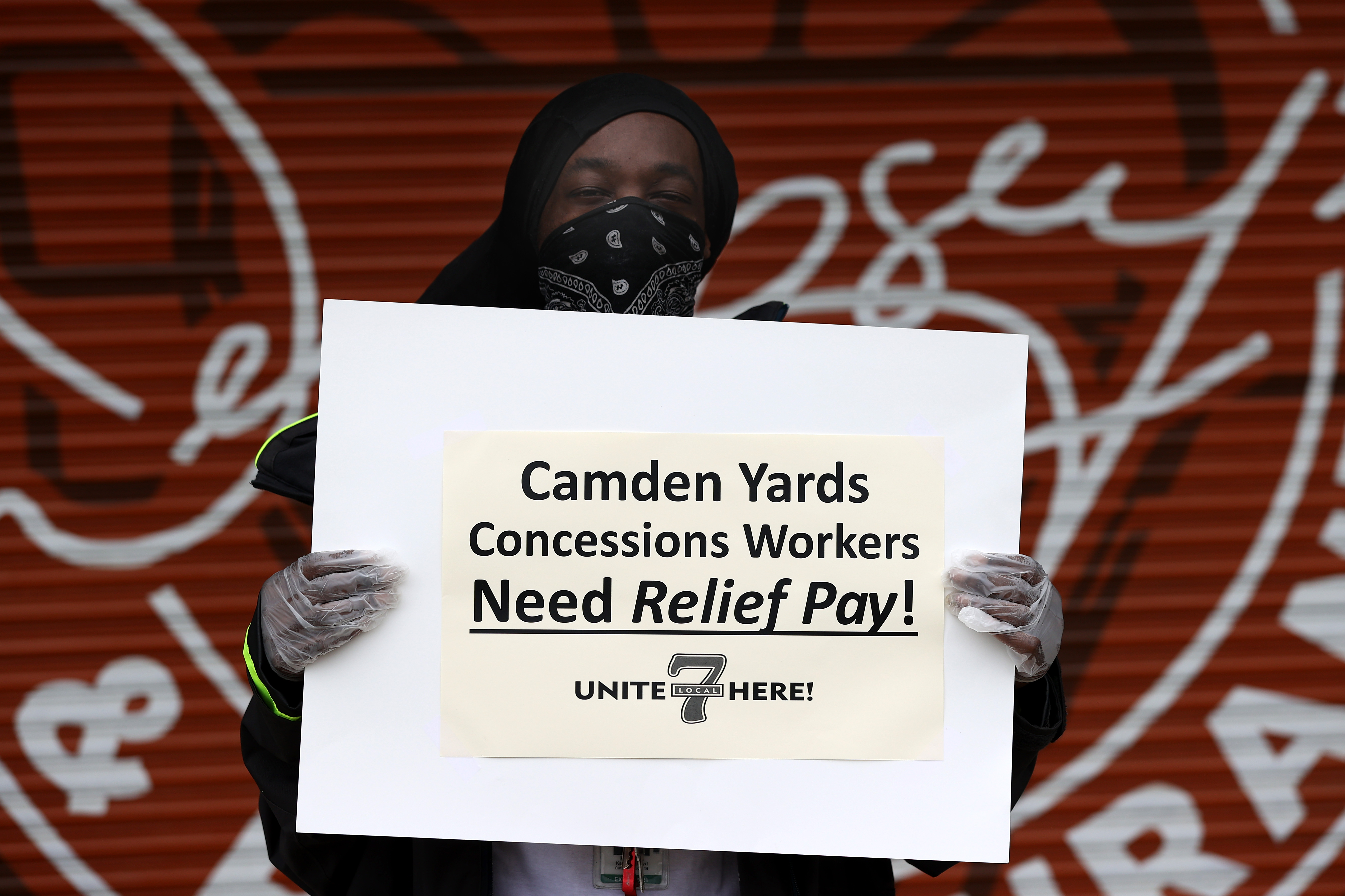 A concession worker protests outside of Camden Yards on May 14, 2020 in Baltimore, Maryland, demanding pay relief. Nearly 3 million Americans filed for unemployment insurance in the past week, bringing the eight-week total to more than 36 million out of work. Wire photography: Rob Carr—Getty Images