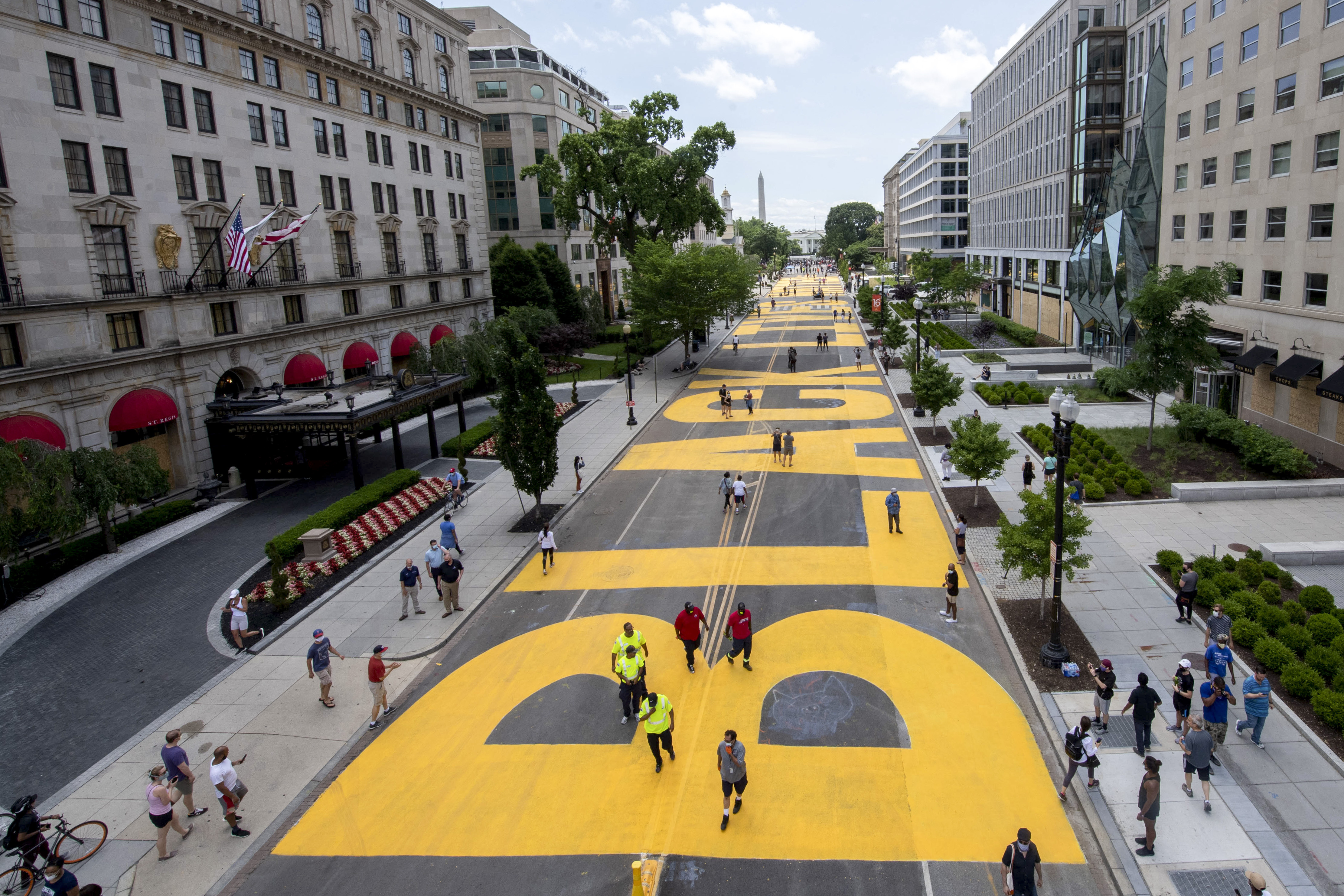 The Washington Monument and the White House are visible behind the words Black Lives Matter sign that has been painted in bright yellow letters on the 16th Street by city workers and activists, Friday, June 5, 2020, in Washington. 