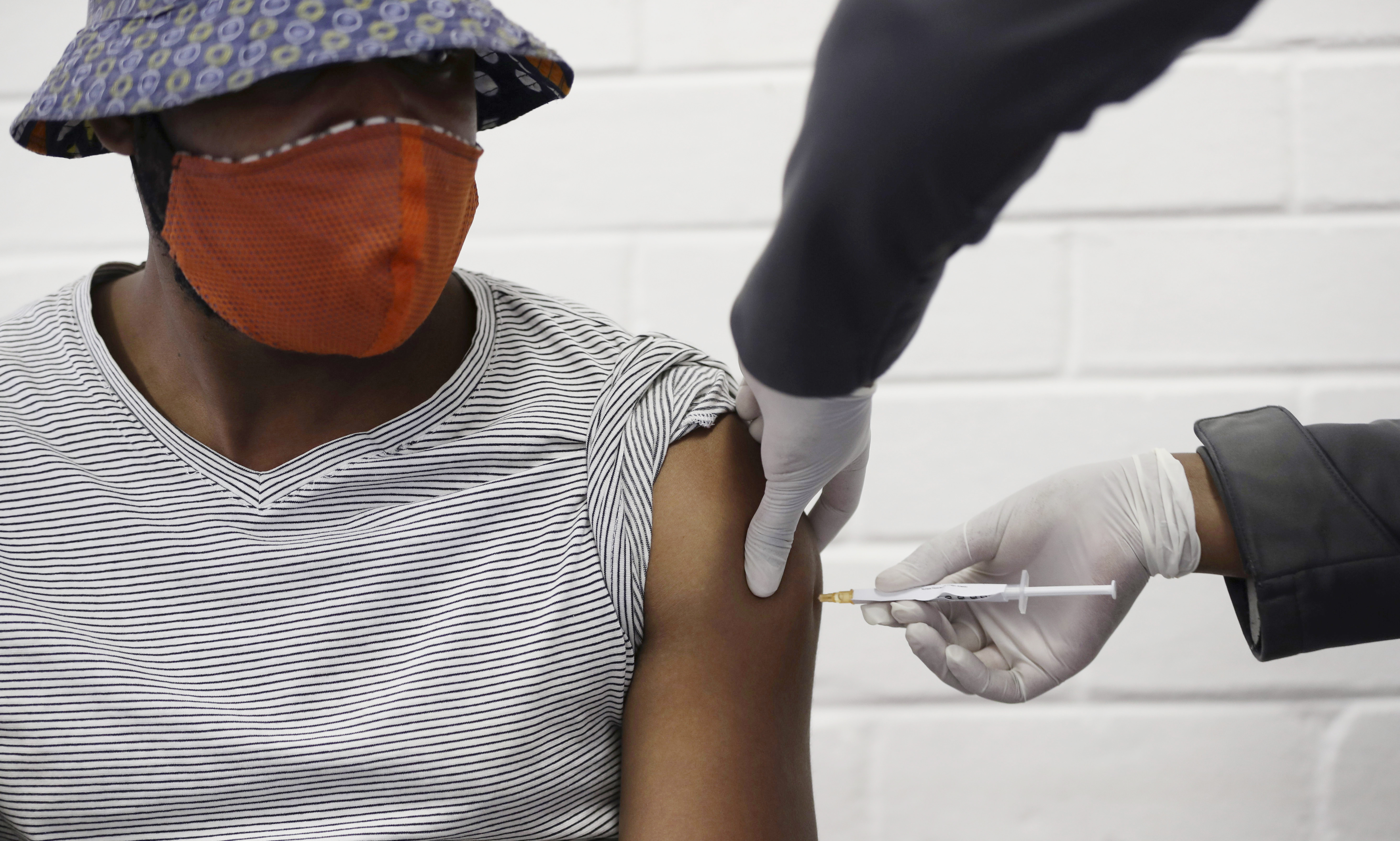In this Wednesday, June 24, 2020 photo, a volunteer receives a COVID-19 test vaccine injection developed at the University of Oxford in Britain, at the Chris Hani Baragwanath hospital in Soweto, Johannesburg, South Africa. People on six continents are testing experimental shots as the race for a COVID-19 vaccine enters a defining summer, with even bigger studies poised to prove if any leading candidate really works - and possibly offer the public a reality check. Siphiwe Sibeko—AP Photo