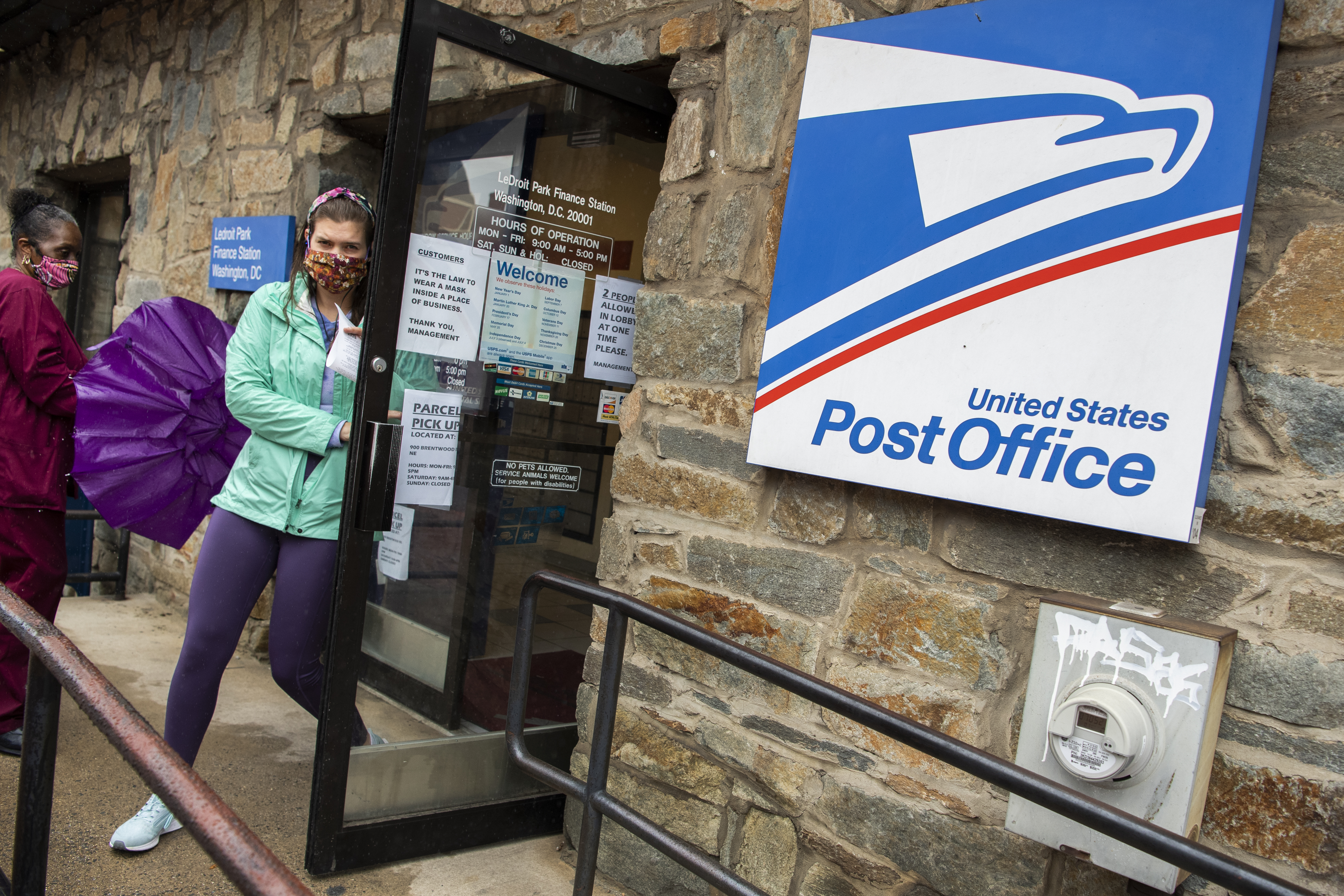 Customers practice the limit of two people at a time in the LeDroit Park Post Office due to the COVID-19 pandemic on Florida Avenue NW, on Thursday, May 28, 2020.