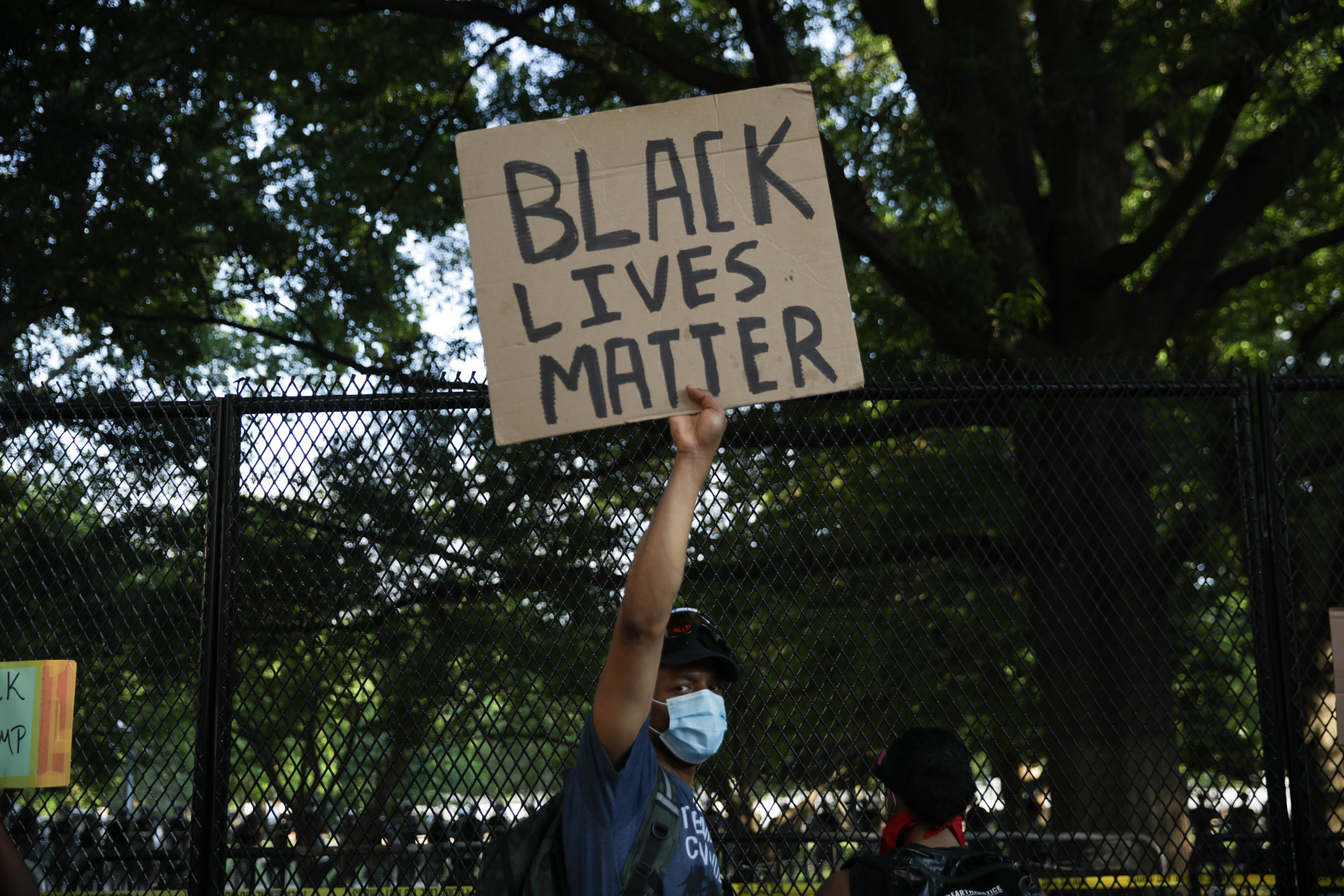A person holds a banner during a protest over the death of George Floyd, an unarmed black man who died after being pinned down by a white police officer in Minneapolis. Photo by Yasin Ozturk/Anadolu Agency via Getty Images