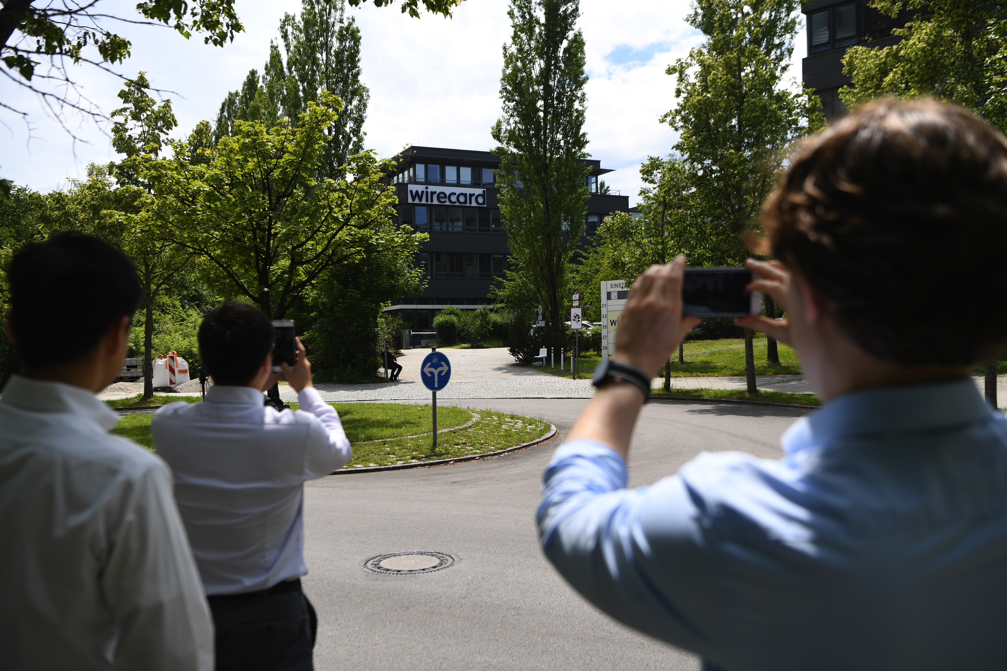 Pedestrians stop to snap photographs of the Wirecard AG headquarters in Munich, Germany, on Thursday, June 25, 2020. Wirecard filed for insolvency, following the arrest of its CEO amid a massive accounting scandal. Wire photography: Andreas Gebert—Bloomberg via Getty Images