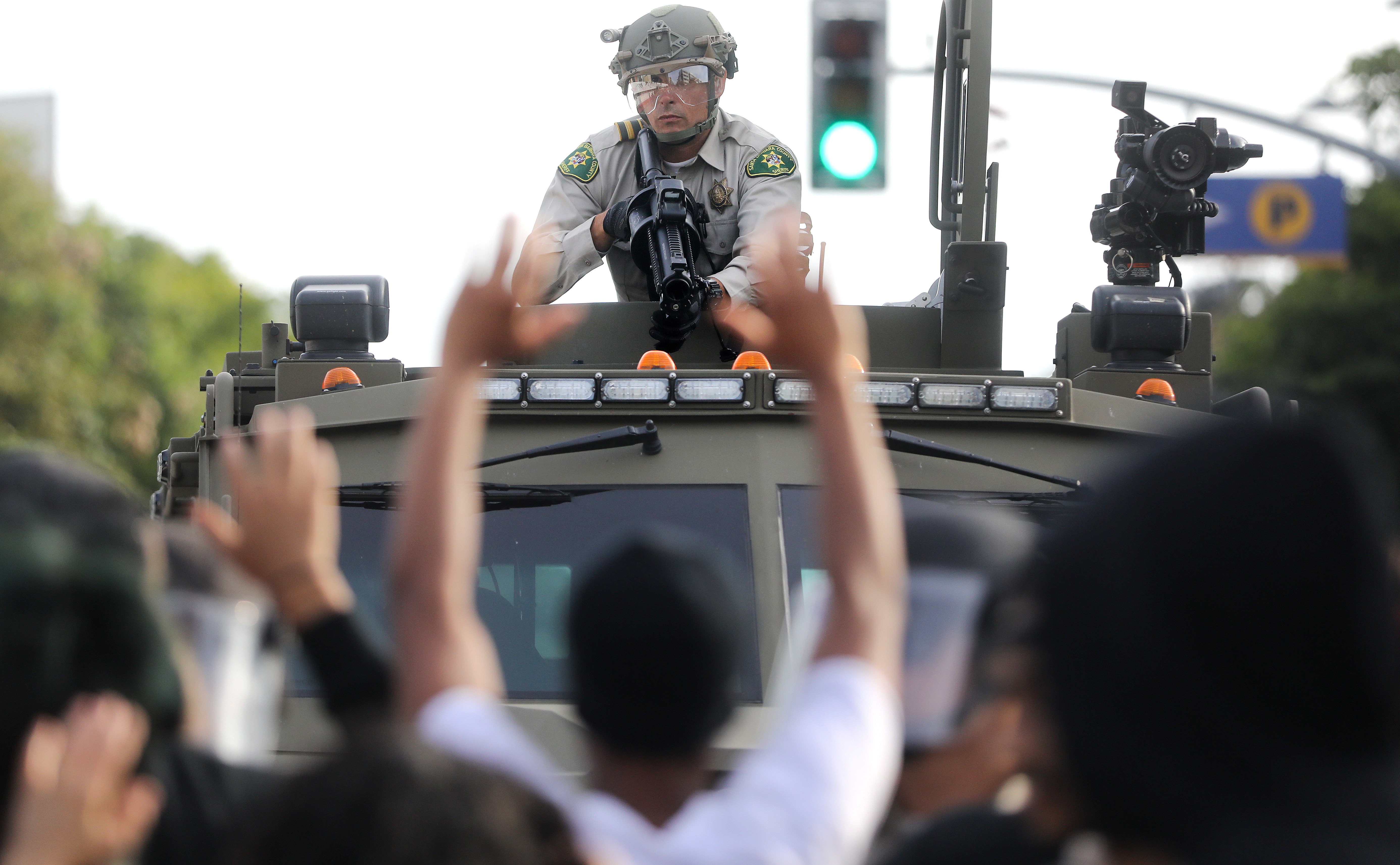 A police officer aims a nonlethal weapon as protesters raise their hands during demonstrations in the aftermath of George Floyd’s death on May 31, 2020 in Santa Monica, California. Looting occurred in the area amid the demonstrations. Wire photography: Mario Tama—Getty Images