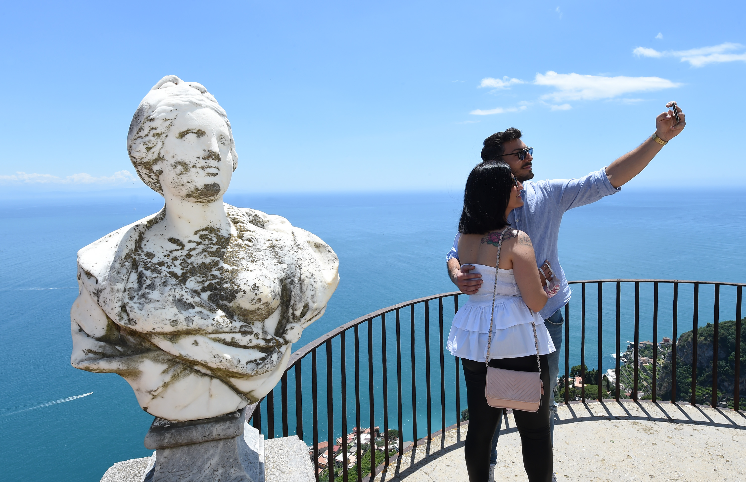 A couple take pictures on Villa Cimbrone's balcony on June 06, 2020 in Ravello, Italy. It's looking increasingly likely that EU countries will ban U.S. travelers as eurozone borders reopen on July 1. Wire photography: Francesco Pecoraro—Getty Images