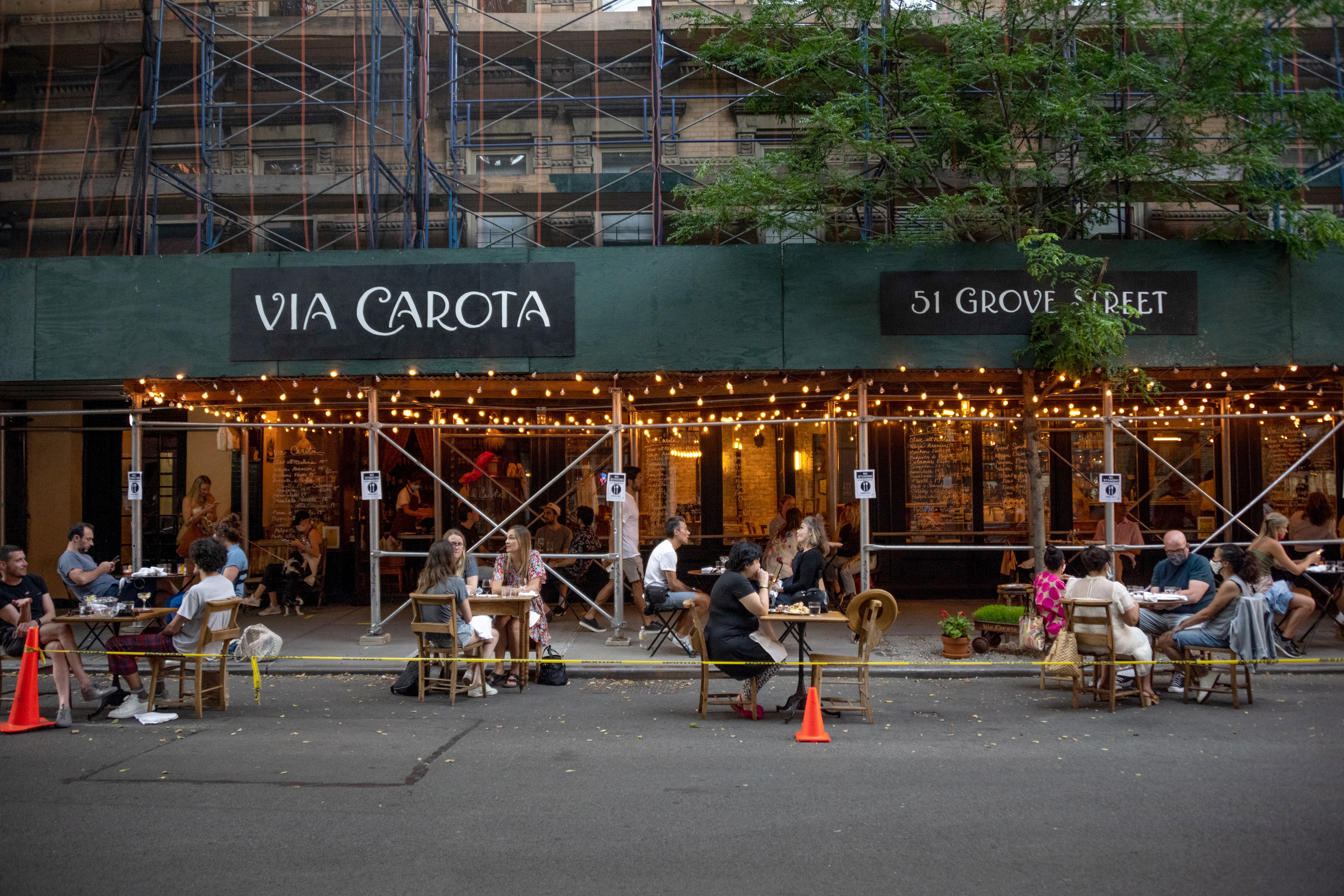NEW YORK, NEW YORK - JUNE 24: Customers are seen sitting outside at Via Carota as the city moves into Phase 2 of re-opening following restrictions imposed to curb the coronavirus pandemic on June 24, 2020 in New York City. Phase 2 permits the reopening of offices, in-store retail, outdoor dining, barbers and beauty parlors and numerous other businesses. New York state plans on re-opening in four phases. (Photo by Alexi Rosenfeld/Getty Images)