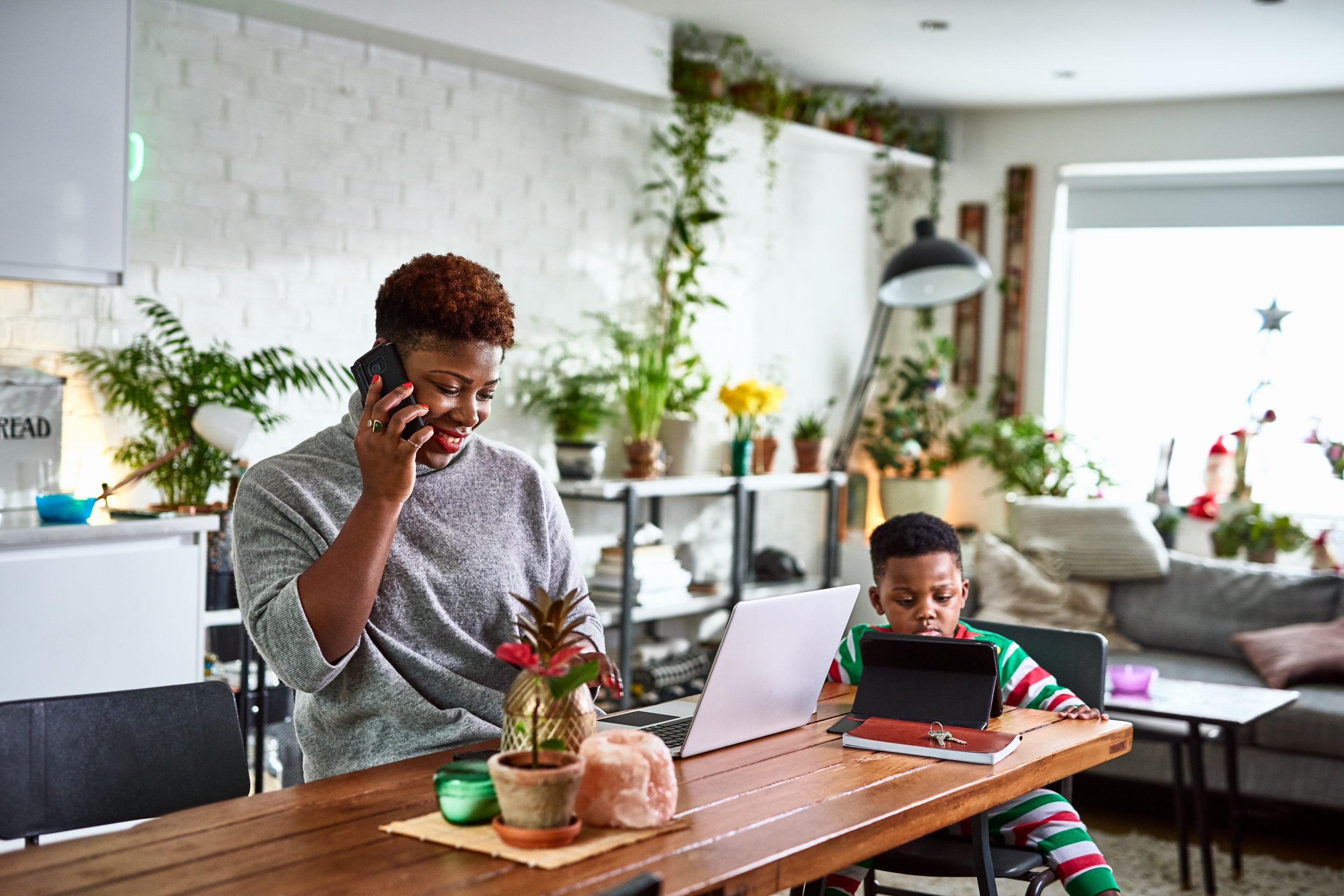 women works from home with son sitting nearby