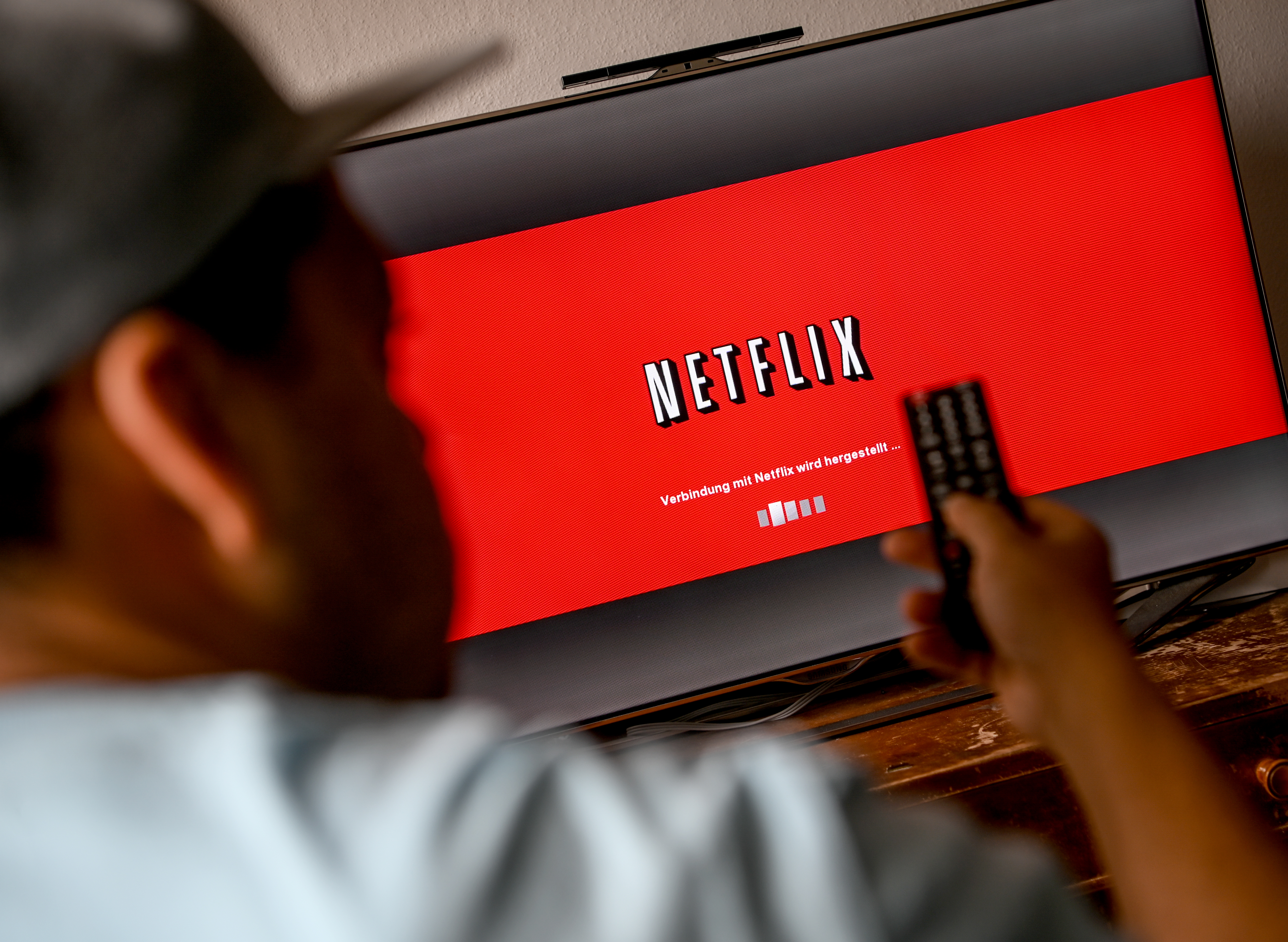 02 April 2020, Berlin: A young man watches series at the provider "Netflix". To prevent infection with the corona virus, many people spend their free time at home. Photo: Britta Pedersen/dpa-Zentralbild/dpa (Photo by Britta Pedersen/picture alliance via Getty Images)