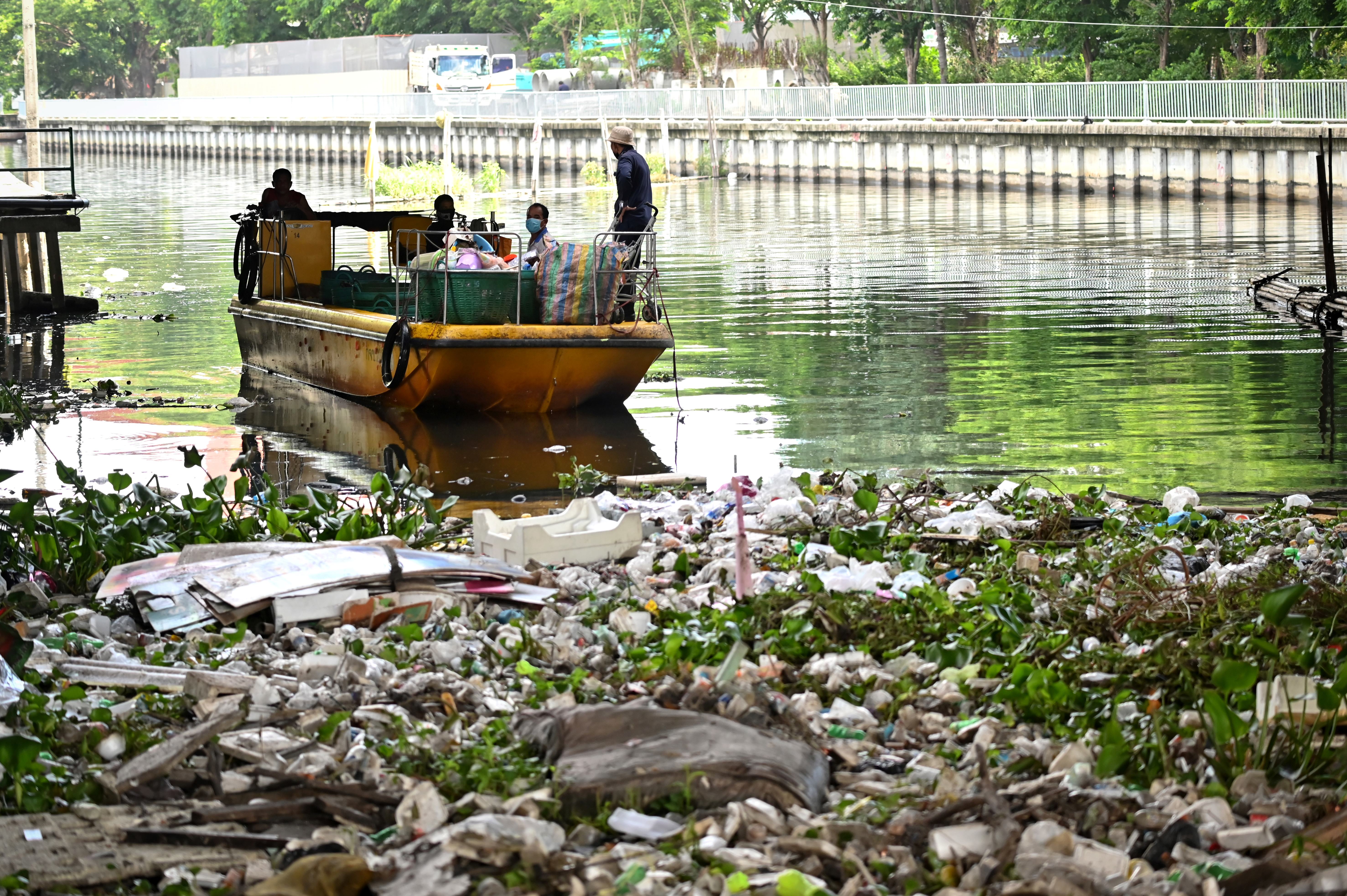 This photo taken on June 9, 2020 shows municipal workers clearing plastic from a canal in Bangkok. - Clogged canals and landfills, polluted rivers and seas, environmentalists warn Thailand's plastic waste has surged in step with home food deliveries during the coronavirus, snuffing out efforts to reduce dependency on single-use plastics. (Photo by Lillian SUWANRUMPHA / AFP) / TO GO WITH Thailand-health-virus-environment, FOCUS by Sophie DEVILLER and Pitcha DANGPRASITH (Photo by LILLIAN SUWANRUMPHA/AFP via Getty Images)