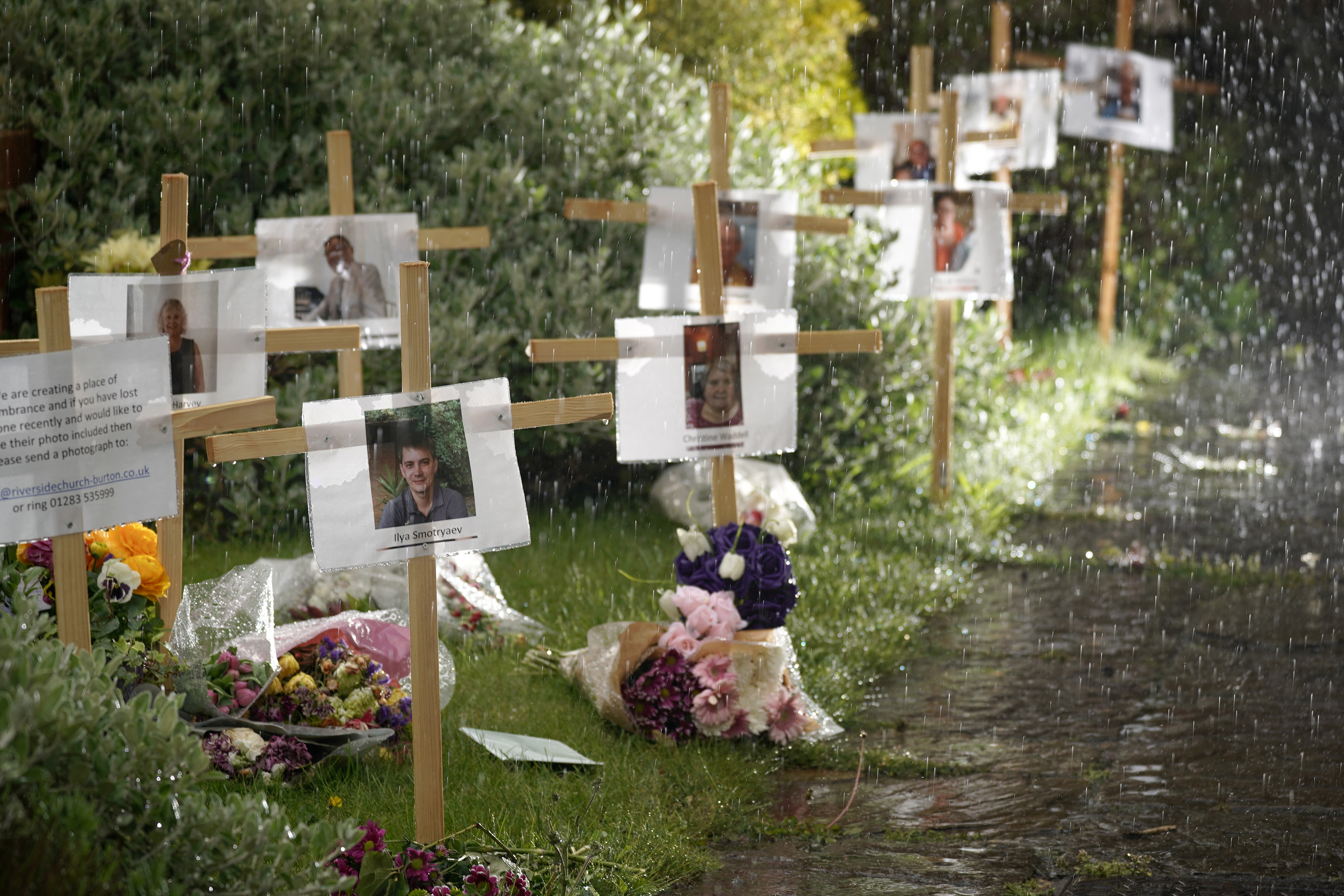 BURTON-ON-TRENT, ENGLAND - APRIL 30: Photographs and memorials for those who died during the lockdown sit outside Riverside Church on April 30, 2020 in Burton-on-Trent, England. The memorial garden has been set up by the church for people to pay their respects to those who have died from coronavirus and other illnesses during the pandemic lockdown. The 13 crosses includes three members from the same family, Jayne Harvey, 62, died from Covid-19 after nursing her parents Keith and Jean McVicar through the virus. British Prime Minister Boris Johnson, who returned to Downing Street this week after recovering from Covid-19, said the country needed to continue its lockdown measures to avoid a second spike in infections. (Photo by Christopher Furlong/Getty Images)
