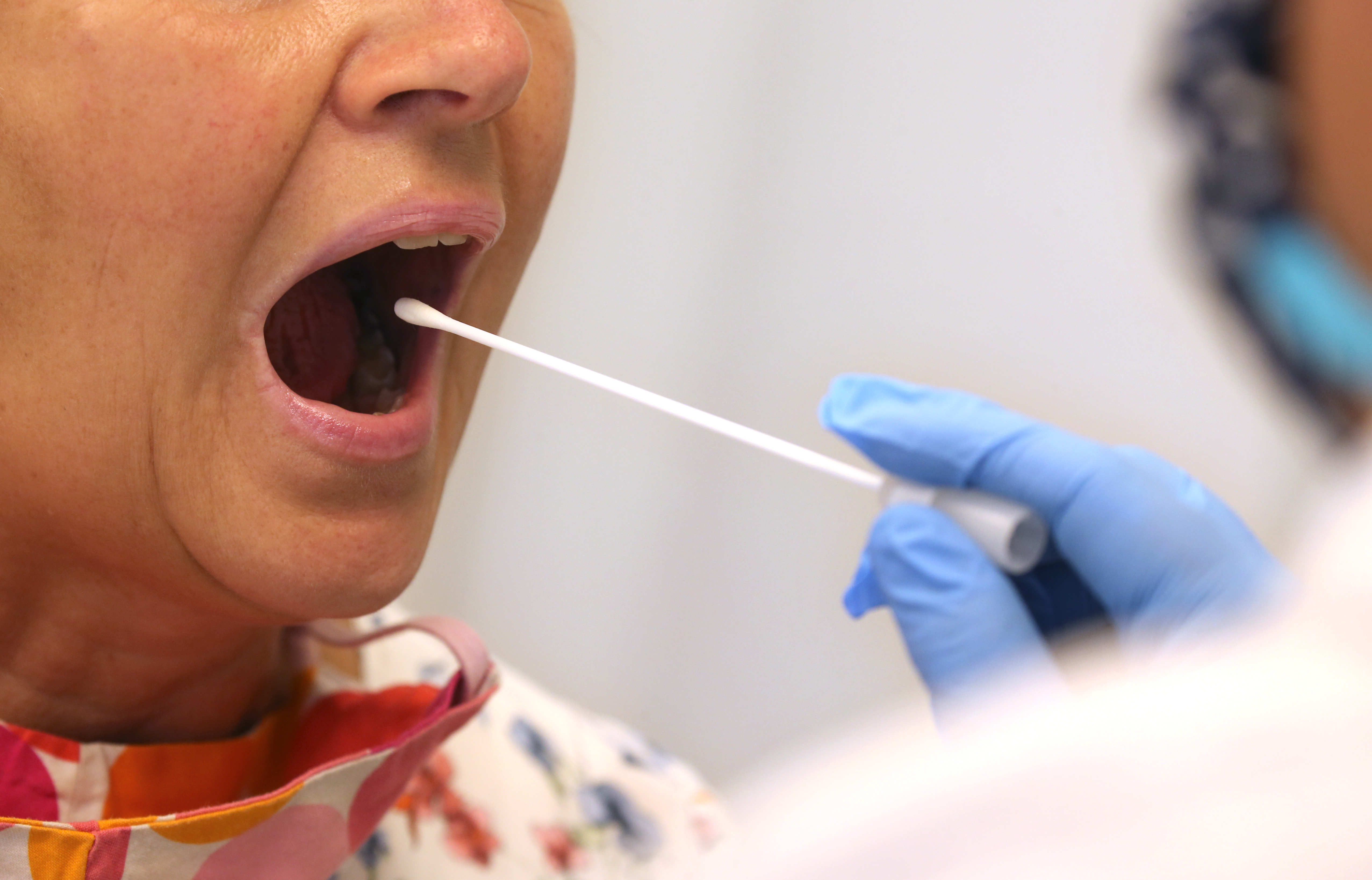 A woman submits to a common coronavirus test, using a swab. Companies are inconsistent in their practice of testing employees for COVID-19. Wire photograhy: Karl-Josef Hildenbrand—dpa via Getty Images