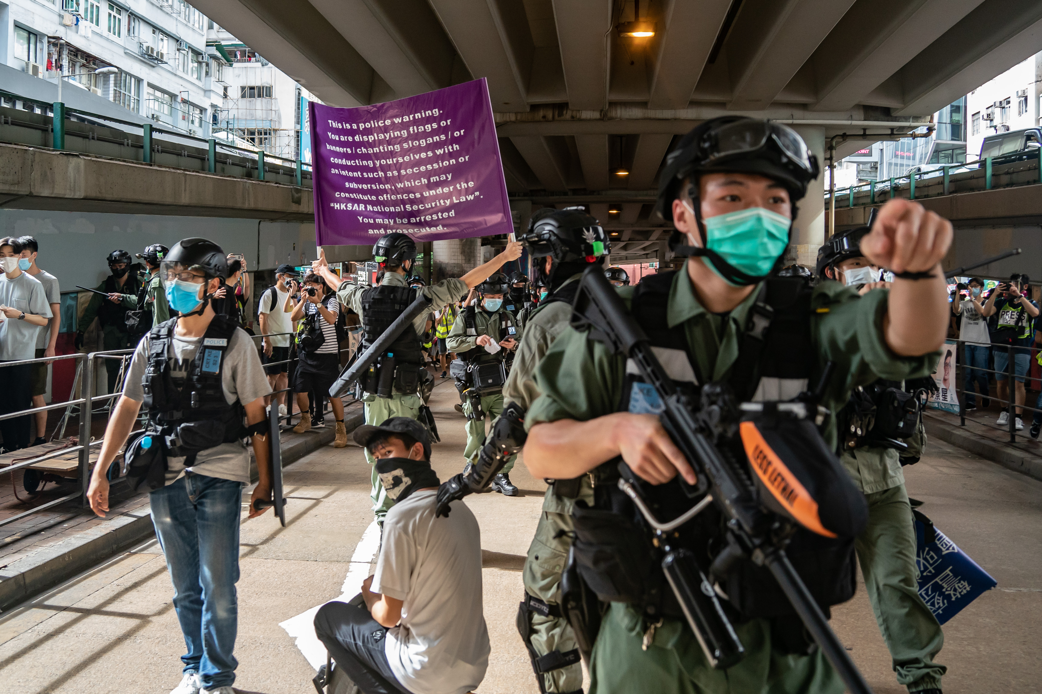 HONG KONG, CHINA - JULY 01: Riot police detain a man as they raise a warning flag during a demonstration against the new national security law on July 1, 2020 in Hong Kong, China. Hong Kong marks the 23rd anniversary of its handover to China on July 1 after Beijing imposed the new national security law. (Photo by Anthony Kwan/Getty Images)