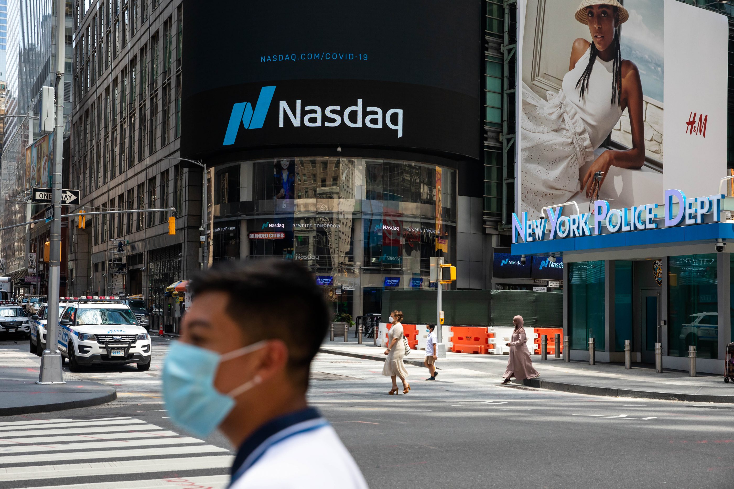 A pedestrian wearing a protective mask passes in front of the Nasdaq MarketSite in the Times Square neighborhood of New York City on Monday, July 20, 2020. Michael Nagle—Bloomberg/Getty Images