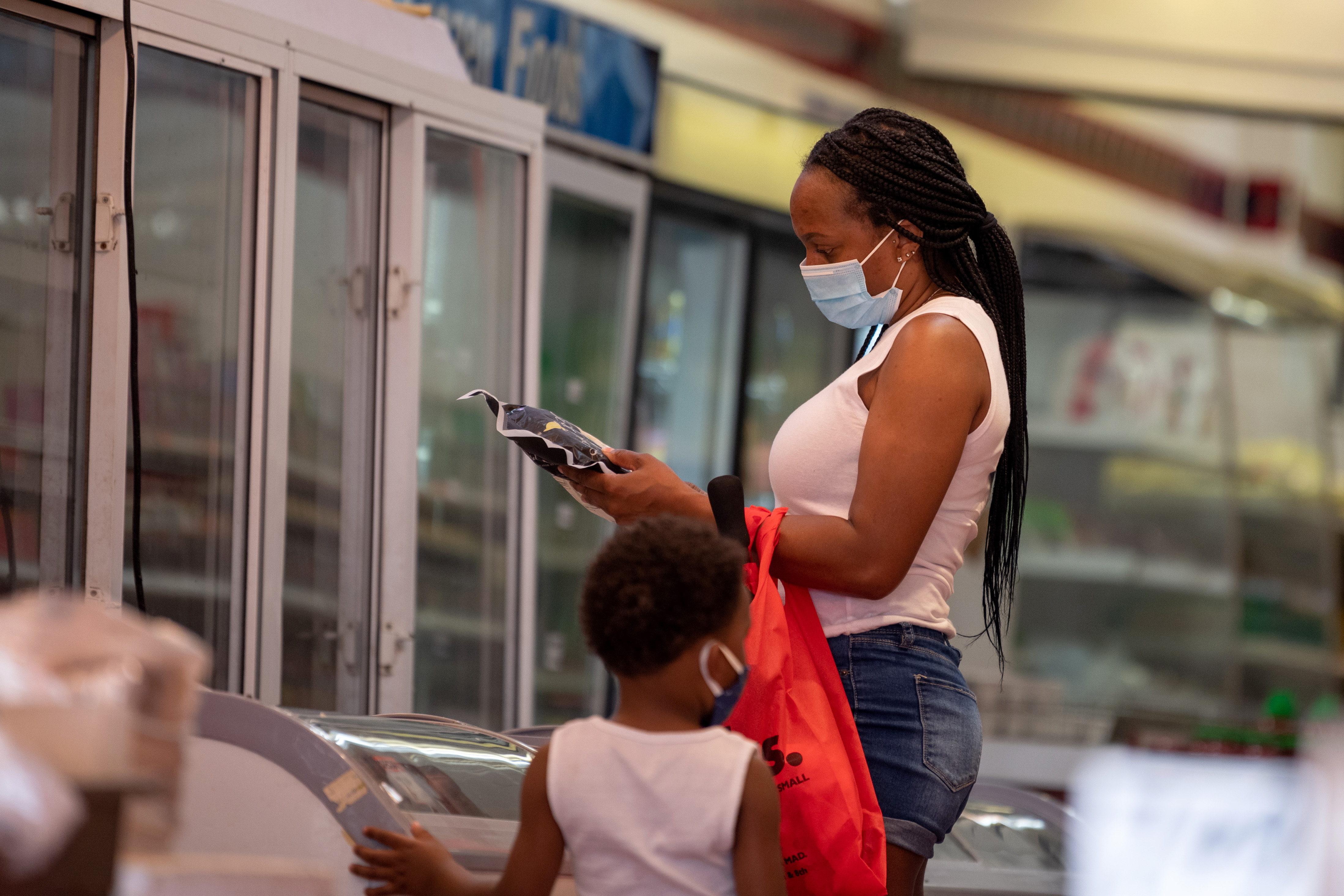 NEW YORK, NEW YORK - JULY 28: A woman wearing a mask is seen shopping at Hung Kee Fish & Meat Food Market in in Chinatown as the city continues Phase 4 of re-opening following restrictions imposed to slow the spread of coronavirus on July 28, 2020 in New York City. The fourth phase allows outdoor arts and entertainment, sporting events without fans and media production. (Photo by Alexi Rosenfeld/Getty Images)