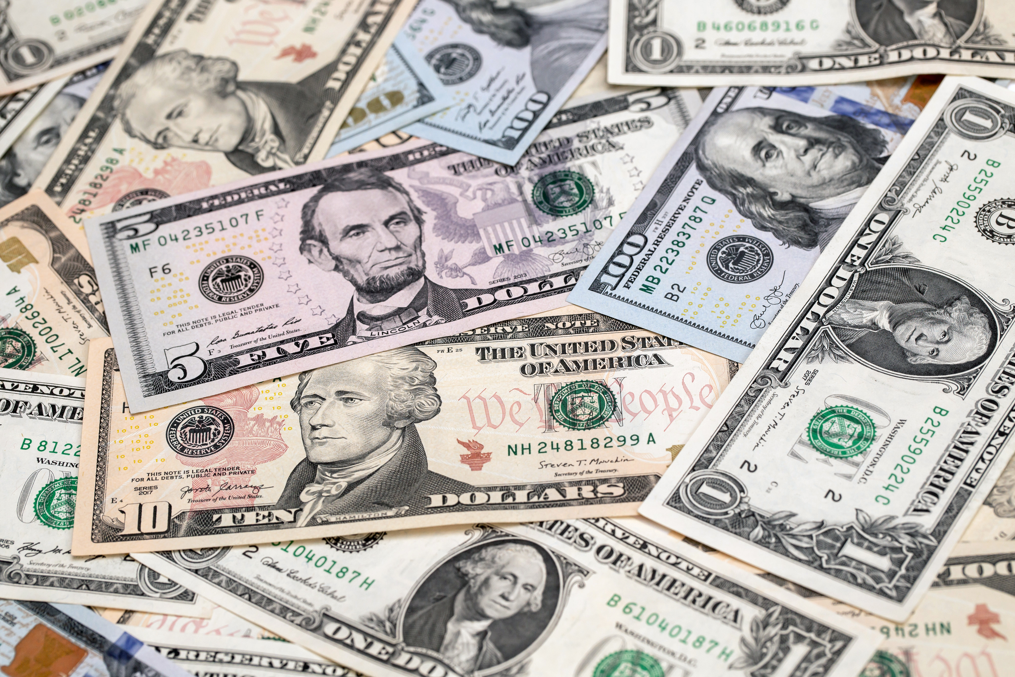 U.S. one-hundred dollar, ten-dollar, five-dollar and one-dollar banknotes are arranged for a photograph in Hong Kong, China, on Thursday, April 23, 2020. The Hong Kong Monetary Authority intervened for a third straight day this week to defend its currency peg as the local dollar touched the strong end of its trading band. Photographer: Paul Yeung/Bloomberg via Getty Images
