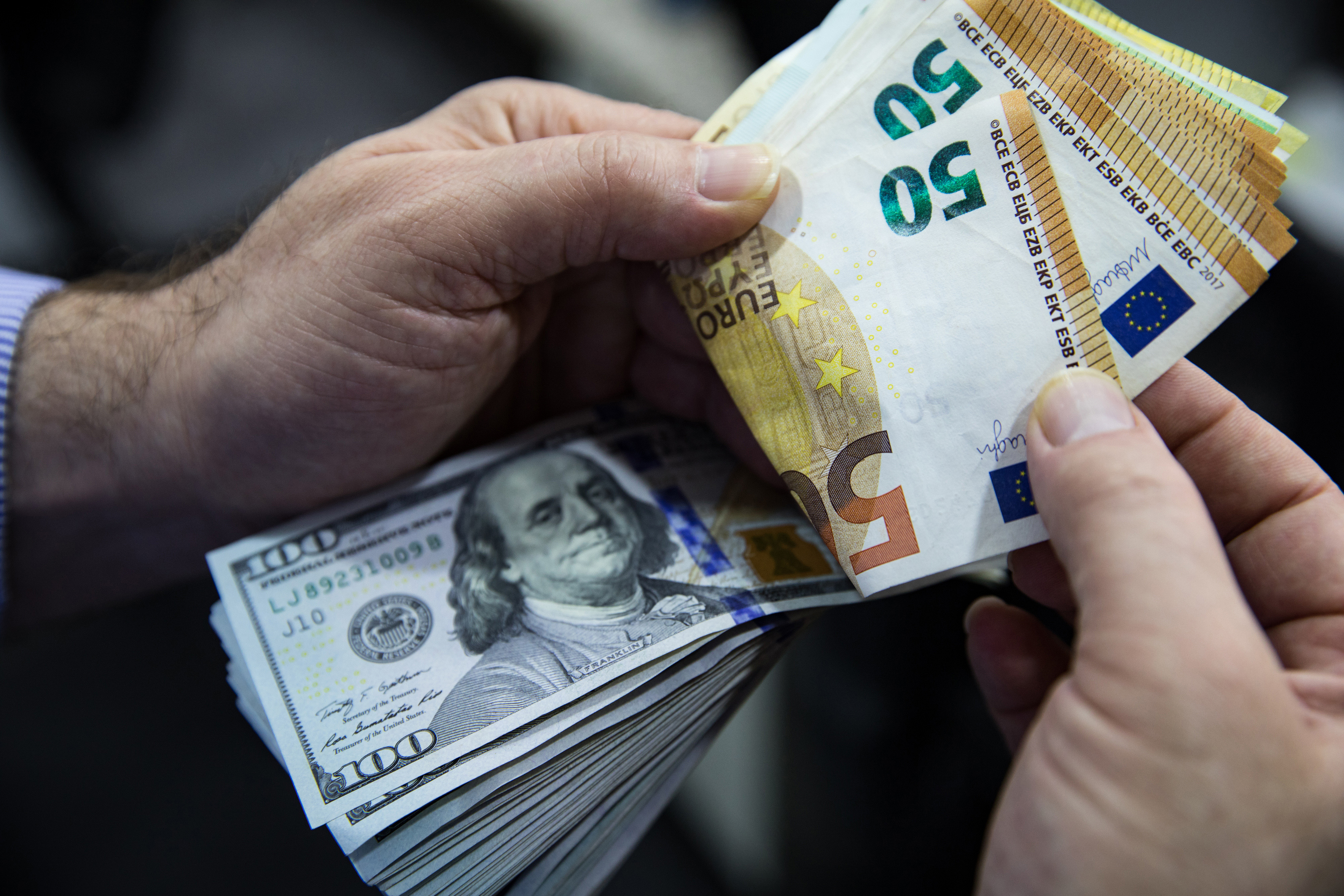 A customer counts 100 U.S. dollar banknotes and 50 euro banknotes inside a foreign currency exchange bureau in the Beyoglu district of Istanbul, Turkey, on Thursday, May 14, 2020. The global demand shock that followed the coronavirus pandemic is exposing a key vulnerability for Turkeys external finances, with stimulus at home worsening an imbalance between imports and exports while creating another pressure point for the lira. Photographer: Kerem Uzel/Bloomberg via Getty Images