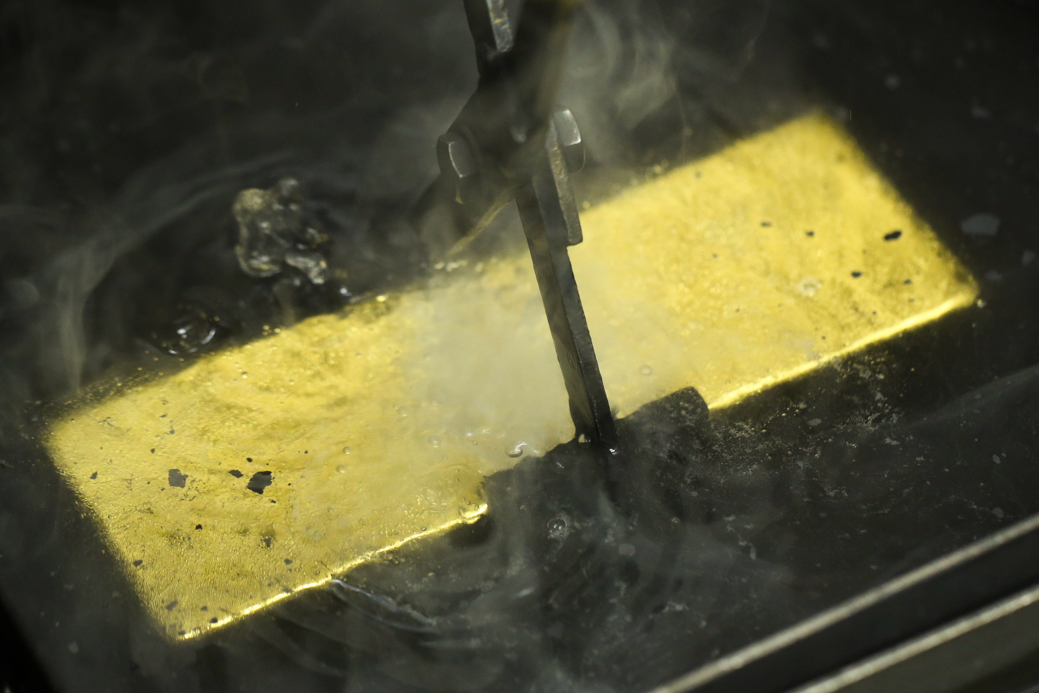 A worker plunges a gold ingot into a cooling bath at the Uralelectromed Copper Refinery, operated by Ural Mining and Metallurgical Co. (UMMC), in Verkhnyaya Pyshma, Russia, on Thursday, July 30, 2020. Gold surged to a fresh record Friday fueled by a weaker dollar and low interest rates. Silver headed for its best month since 1979. Photographer: Andrey Rudakov/Bloomberg via Getty Images