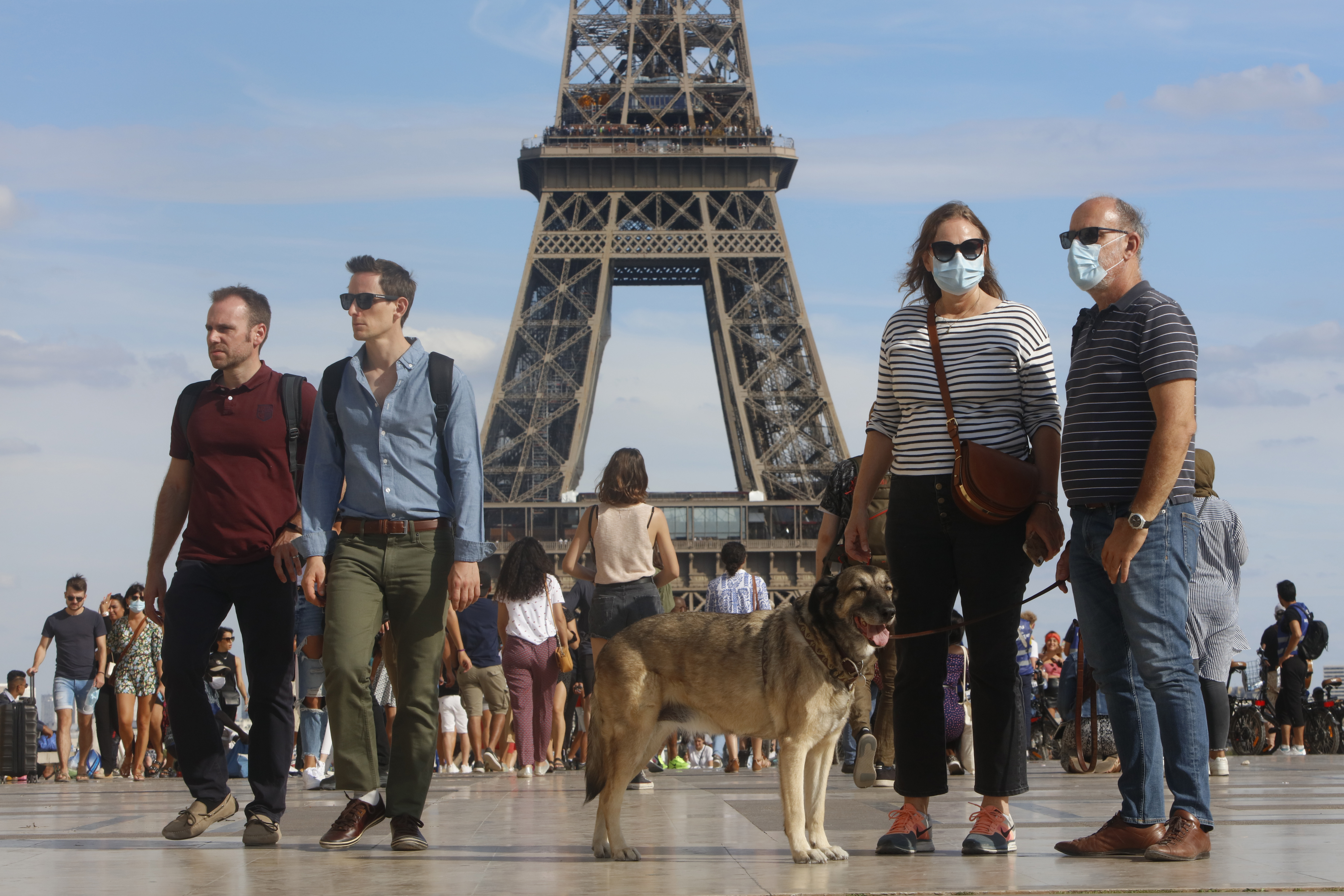 Tourists wearing a protective mask walk a front the Eiffel Tower in France. On August 2, 2020. (Photo by Mehdi Taamallah/NurPhoto via Getty Images)