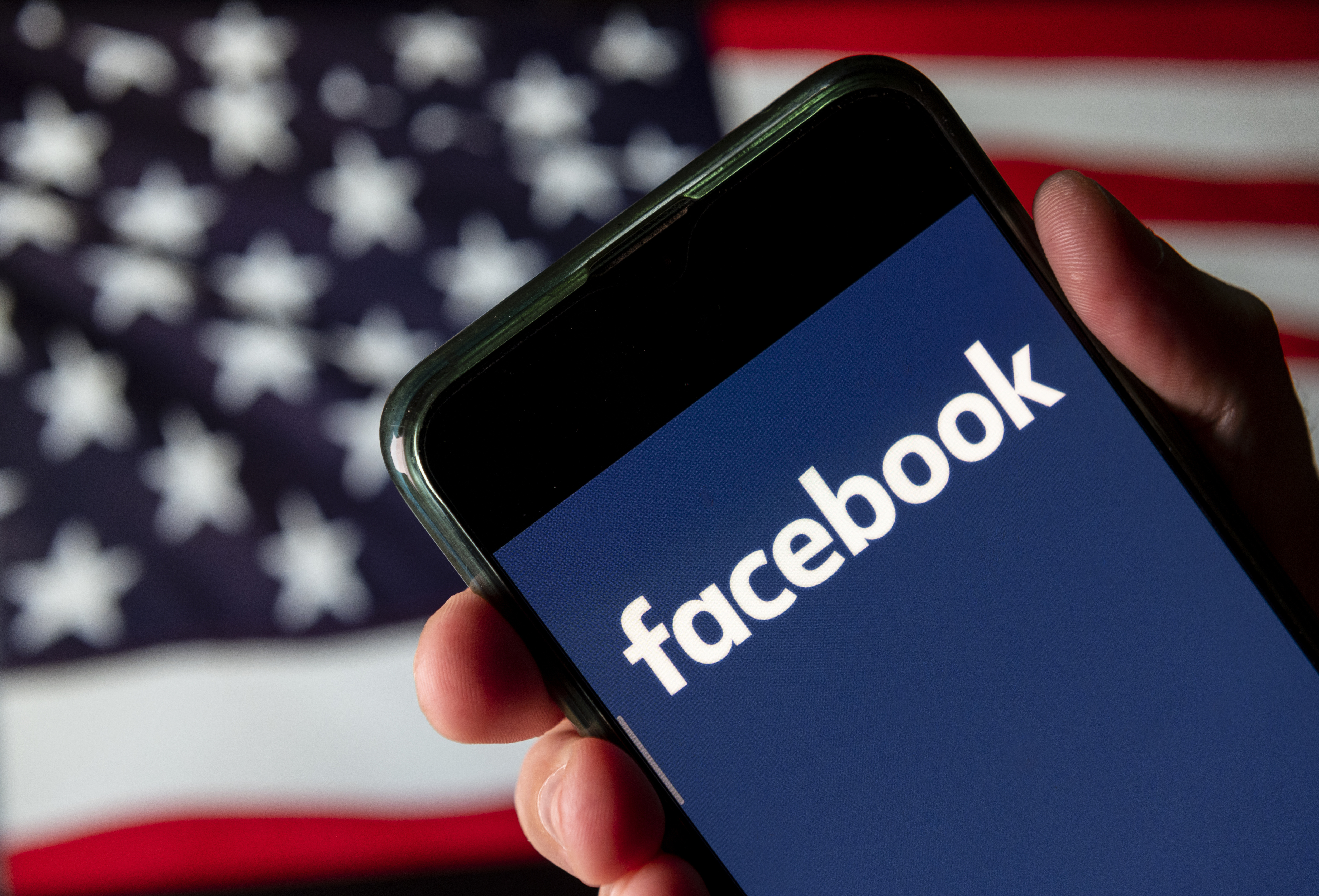 CHINA - 2020/08/11: In this photo illustration the American online social media and social networking service company, Facebook logo is seen on an Android mobile device with United States of America flag in the background.