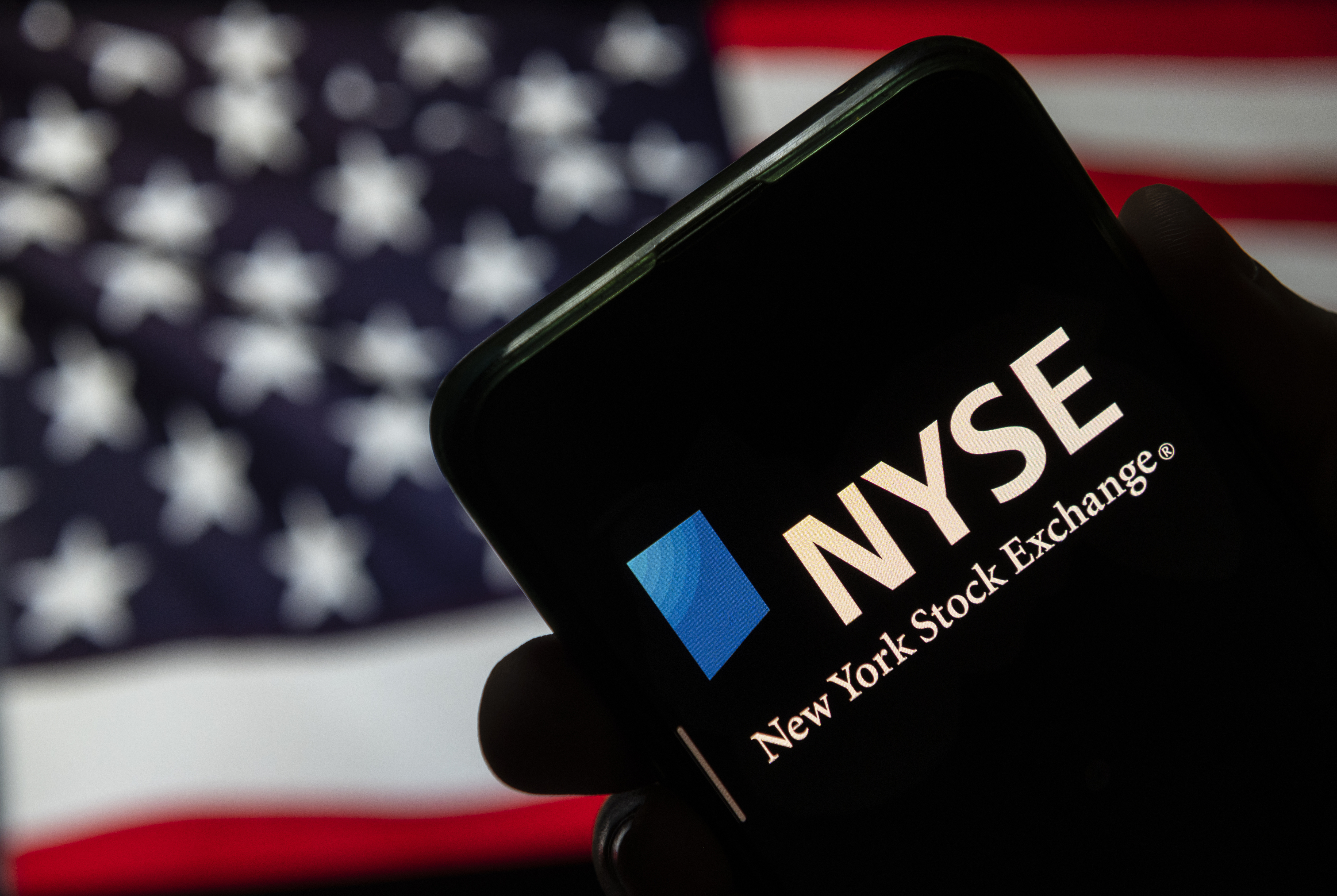 CHINA - 2020/08/11: In this photo illustration the American Stock Exchange index, NYSE logo is seen on an Android mobile device with United States of America flag in the background.