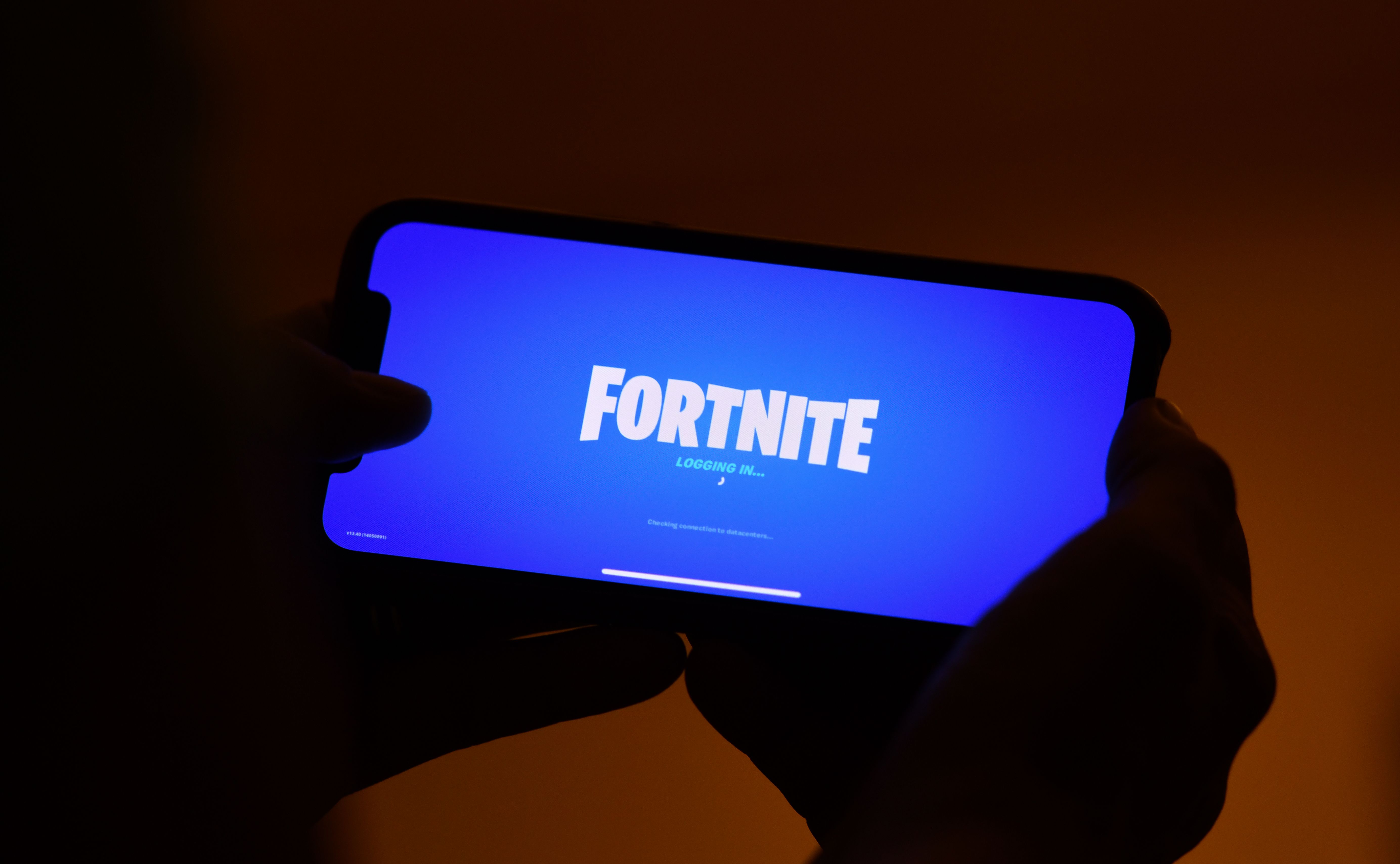 This illustration picture shows a person logging into Epic Games' Fortnite on their smartphone in Los Angeles on August 14, 2020. - Apple and Google on August 13, 2020 pulled video game sensation Fortnite from their mobile app shops after its maker Epic Games released an update that dodges revenue sharing with the tech giants. (Photo by Chris DELMAS / AFP) 