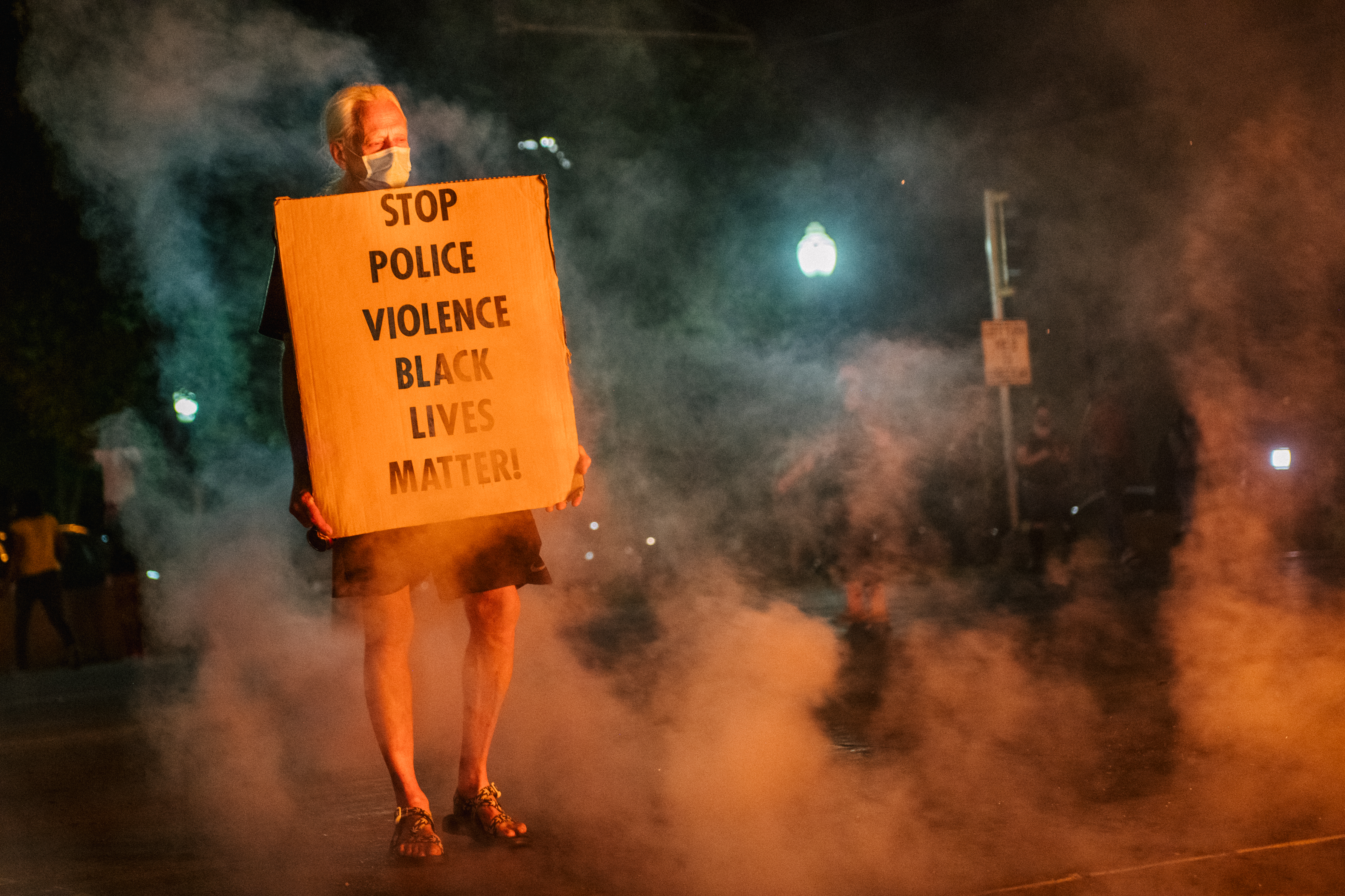 KENOSHA, WI - AUGUST 24: A man stands with a sign on August 24, 2020 in Kenosha, Wisconsin. This is the second night of rioting after the shooting of Jacob Blake, 29, on August 23. Blake was shot multiple times in the back by Wisconsin police officers after attempting to enter into the drivers side of a vehicle.  (Photo by Brandon Bell/Getty Images)