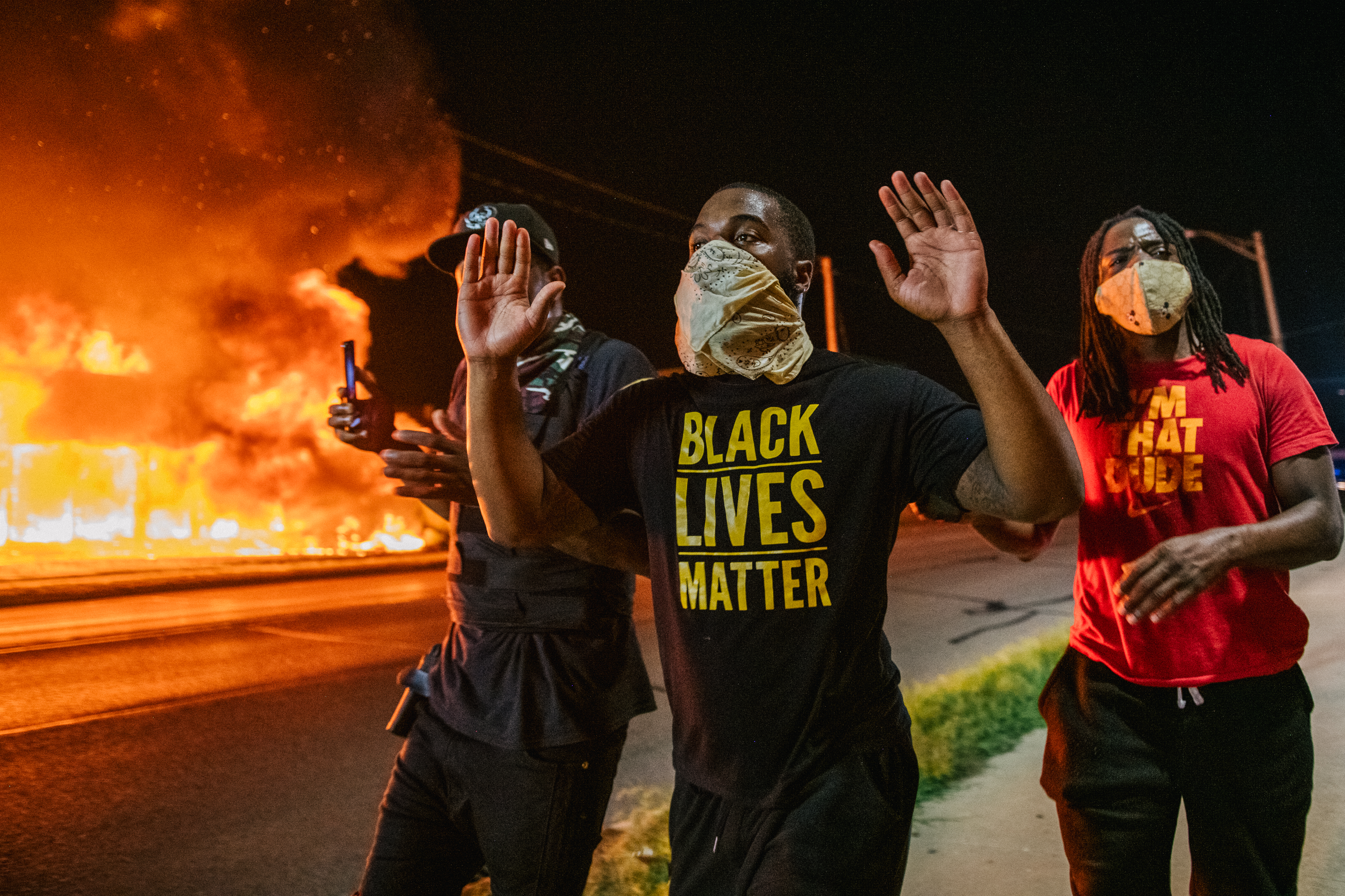 KENOSHA, WI - AUGUST 24: Men walk towards law enforcement with their hands up on August 24, 2020 in Kenosha, Wisconsin. A second night of civil unrest occurred after the shooting of Jacob Blake, 29, on August 23. Blake was shot multiple times in the back by Wisconsin police officers after attempting to enter into the drivers side of a vehicle. (Photo by Brandon Bell/Getty Images)