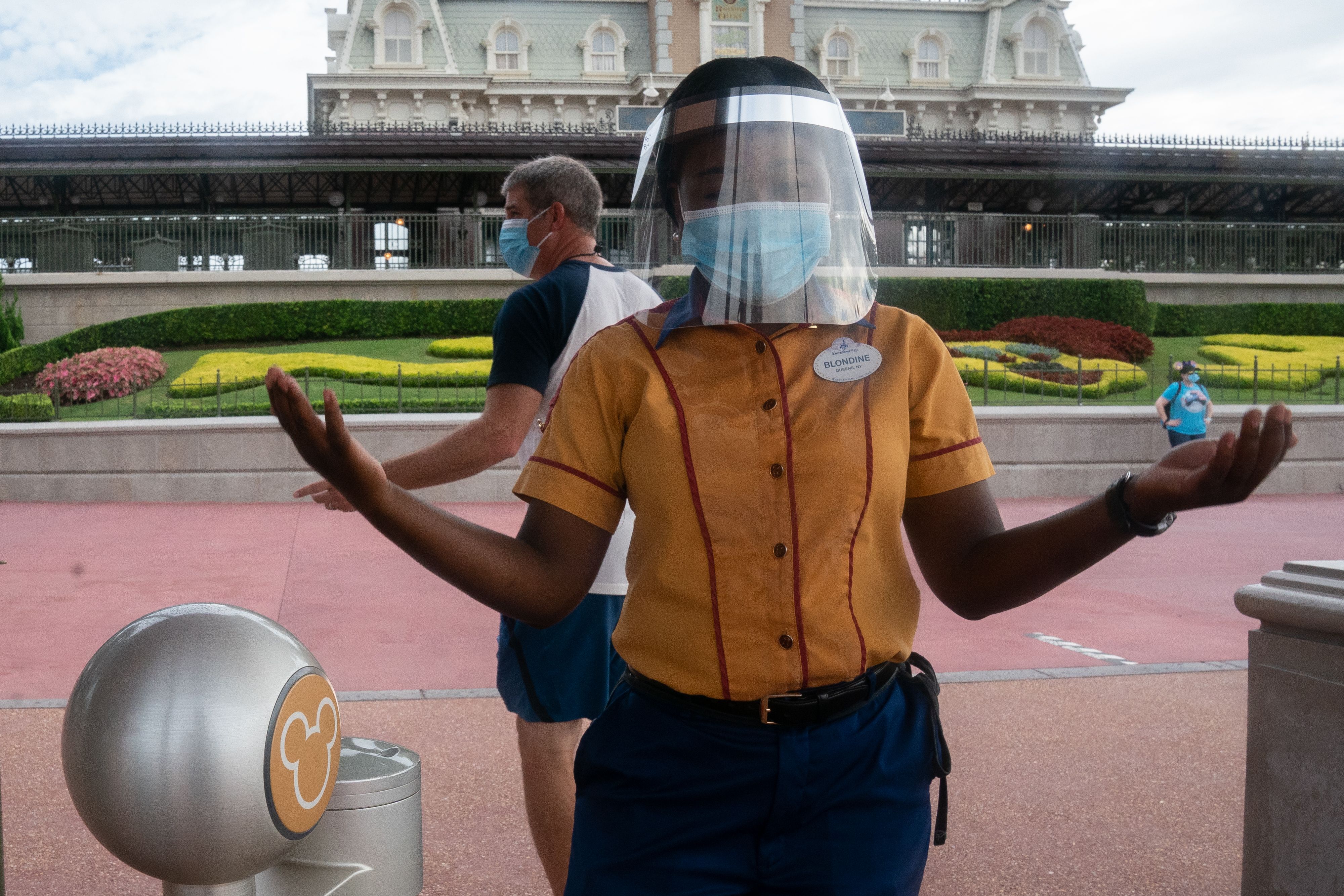 An employee at Walt Disney World Resort's Magic Kingdom wears a facemask and face shield at the entrance to the park during the COVID-19 pandemic in Orlando on July 23, 2020. Photo by BRYAN R. SMITH/AFP via Getty Images