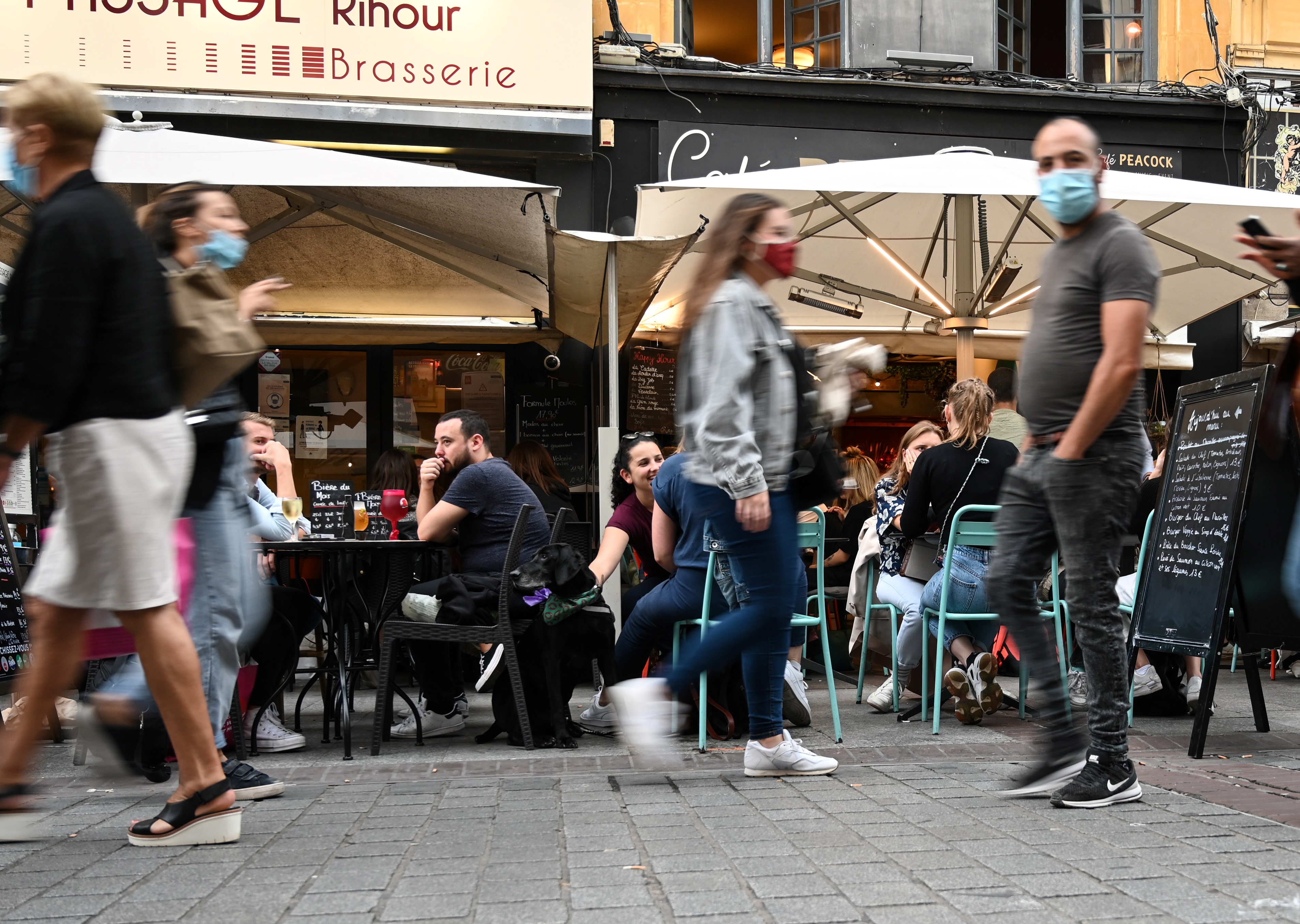 People sit at a cafe's terrace on September 9, 2020 in Lille, northern France. - From this Monday evening and for a fortnight, restaurants, night grocery stores, and bars will close at 12:30 a.m. every day in Lille to prevent the spread of the covid-19 pandemic caused by the novel coronavirus. (Photo by DENIS CHARLET / AFP) (Photo by DENIS CHARLET/AFP via Getty Images)