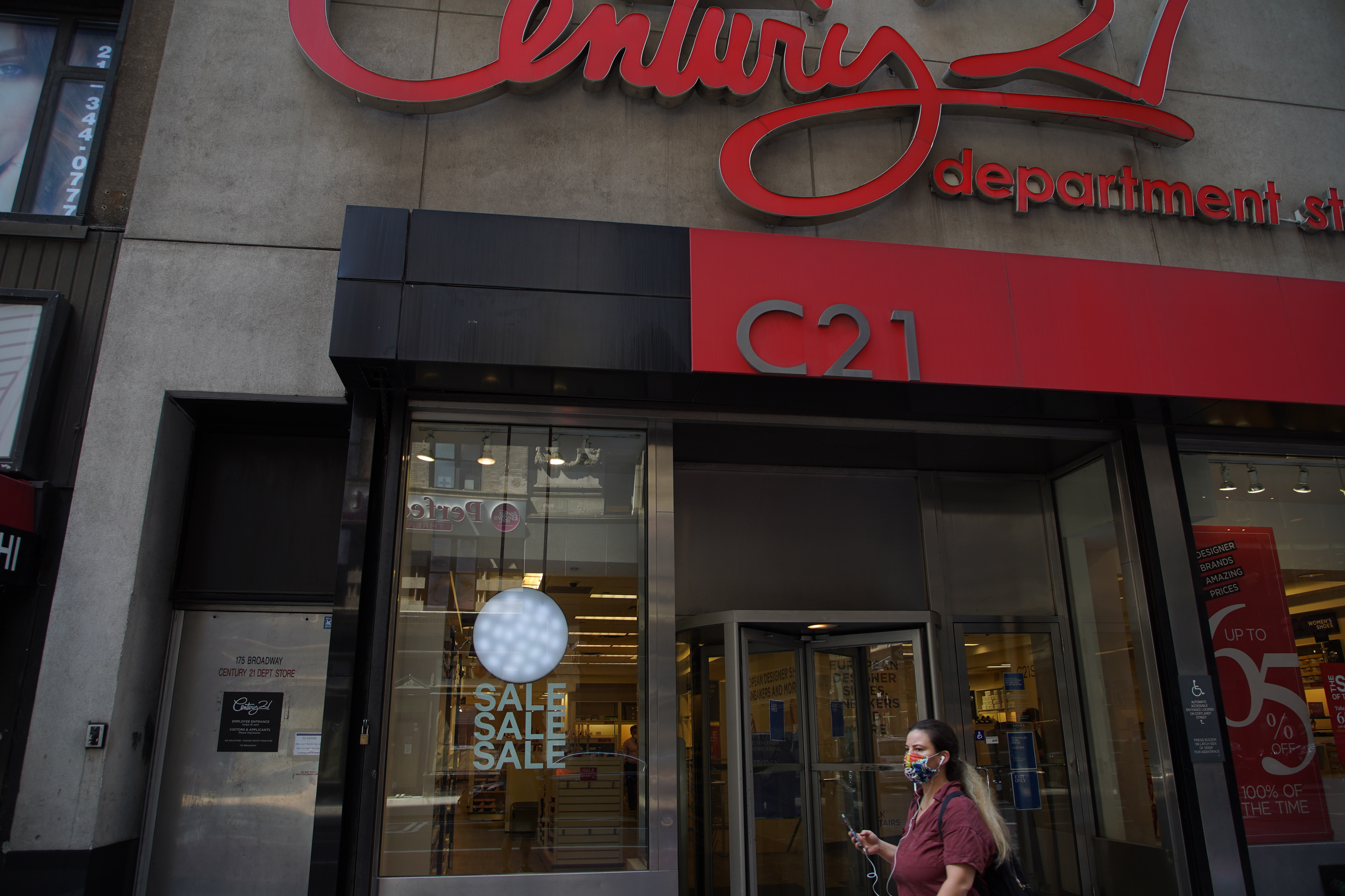 NEW YORK, NEW YORK - AUGUST 02: A person wearing a protective face mask walks near the Century 21 retail store in Lower Manhattan during Phase 4 of re-opening following restrictions imposed to curb the coronavirus pandemic on August 2, 2020 in New York, New York. The fourth phase allows outdoor arts and entertainment, sporting events without fans and media production. (Photo by Rob Kim/Getty Images)