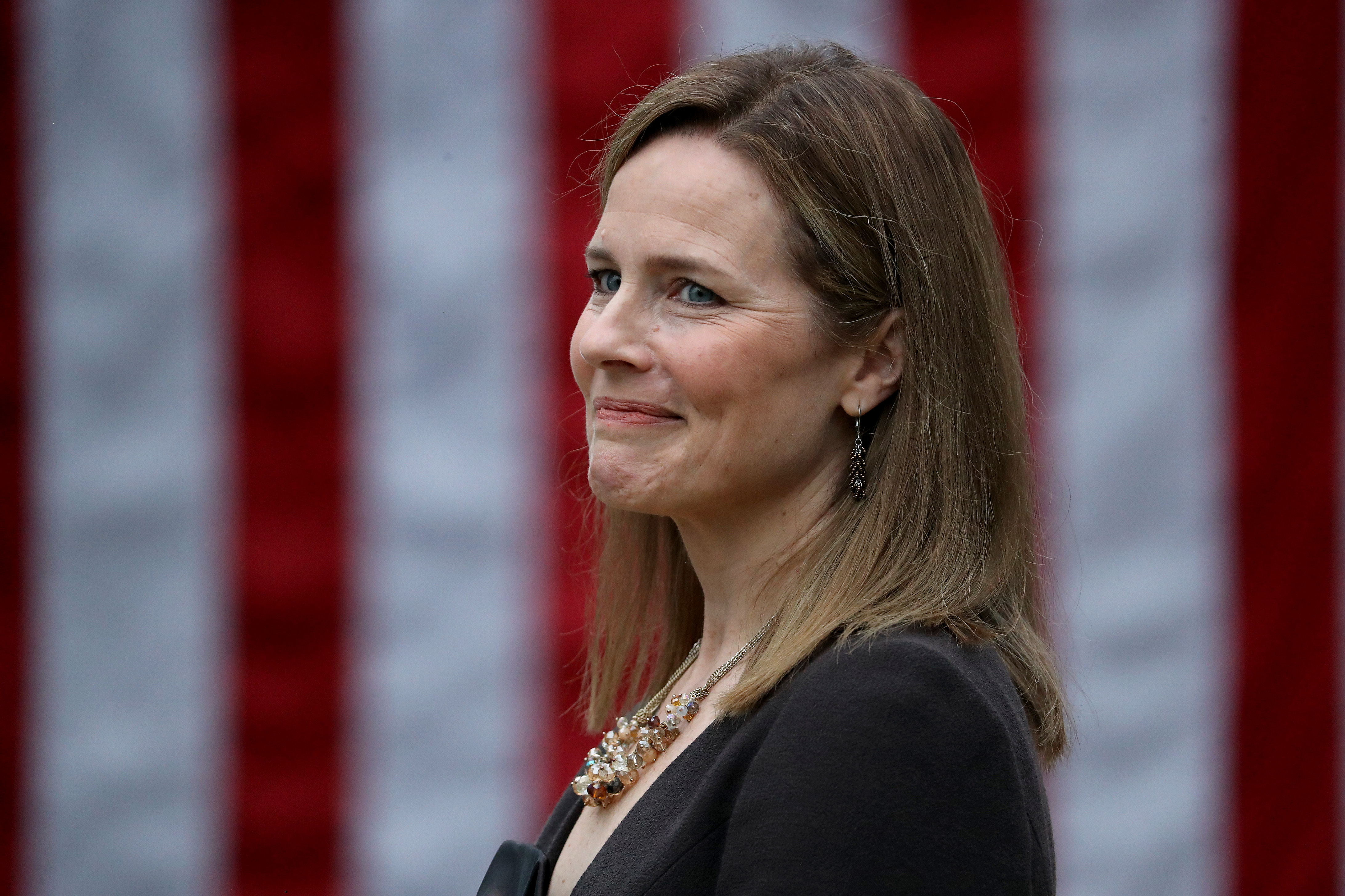 Seventh U.S. Circuit Court Judge Amy Coney Barrett looks on while being introduced by U.S. President Donald Trump as his nominee to the Supreme Court during an event in the Rose Garden at the White House September 26, 2020 in Washington, DC. With 38 days until the election, Trump tapped Barrett to be his third Supreme Court nominee in just four years and to replace the late Associate Justice Ruth Bader Ginsburg, who will be buried at Arlington National Cemetery on Tuesday. Chip Somodevilla/Getty Images